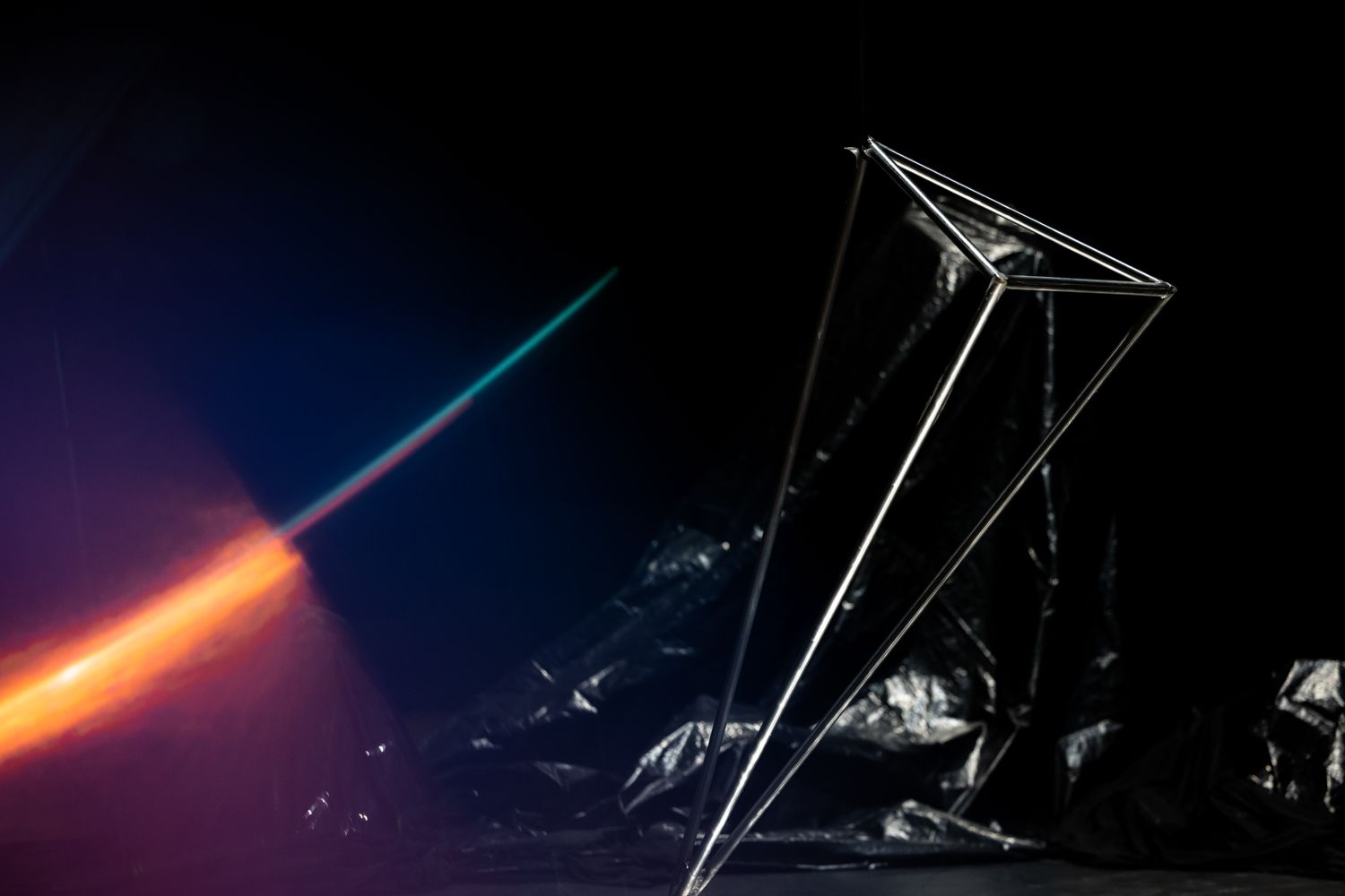 Dramatic light trails and geometric shapes illuminate a dark performance space.