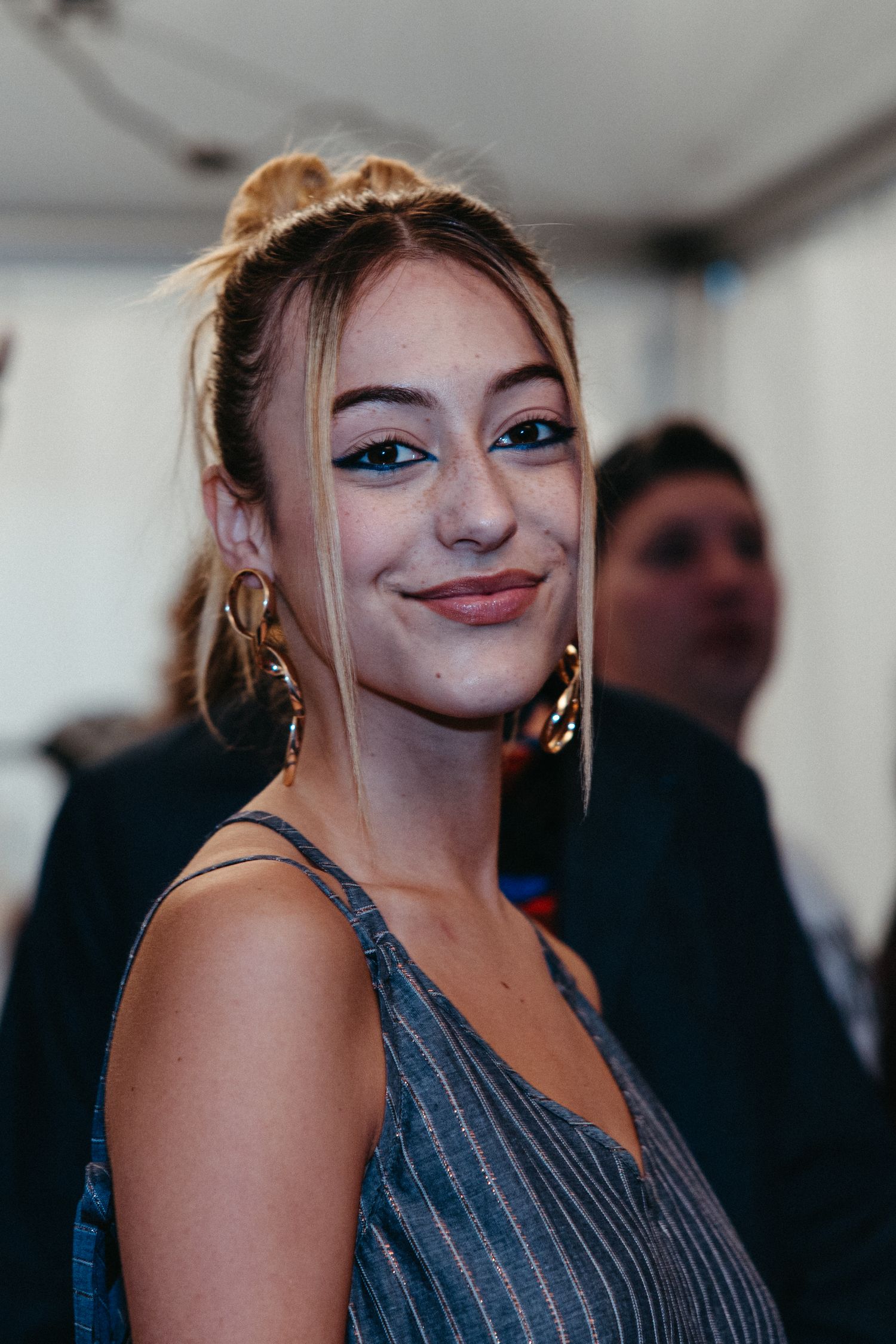 Sequence of five cropped shots showing someone looking and smiling at different angles while wearing a gray striped top.