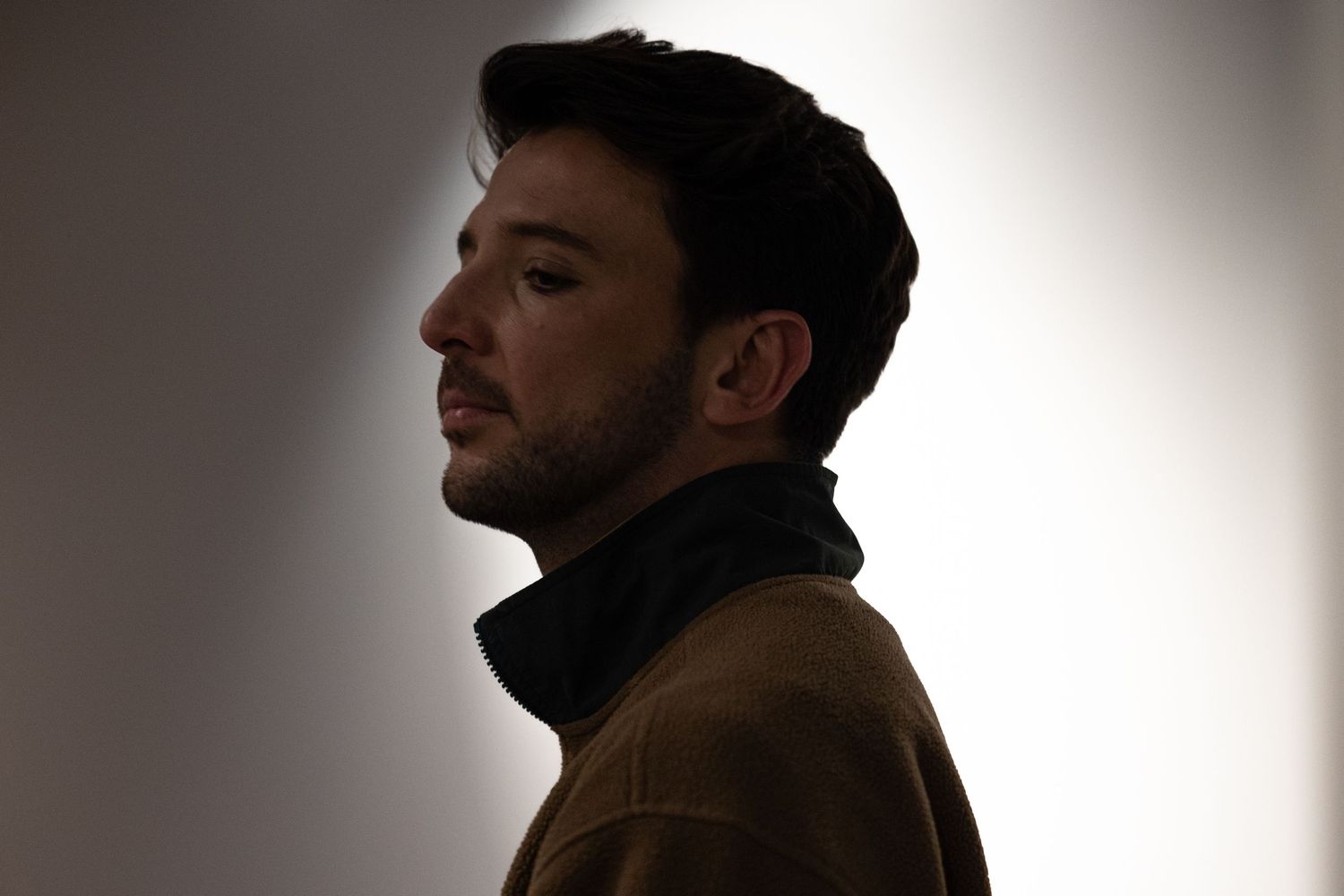 Dark silhouetted profile portraits showing a person's head and shoulders against a light gradient background.