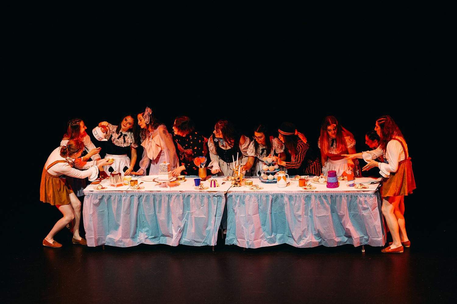 Performers recreate The Last Supper in theatrical stage production with dramatic lighting and period costumes.