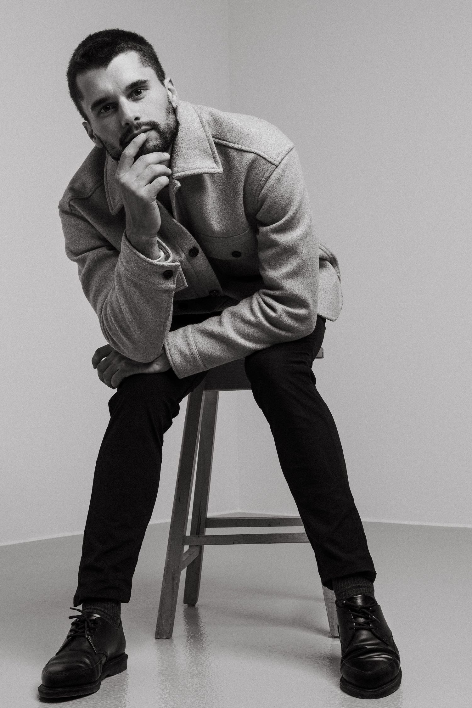 A series of black and white photos showing someone in casual attire sitting on a chair in different contemplative poses.