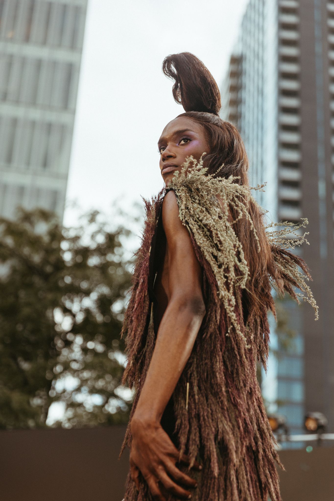 A woman with dreadlocks poses in various angles against an urban backdrop with tall buildings.