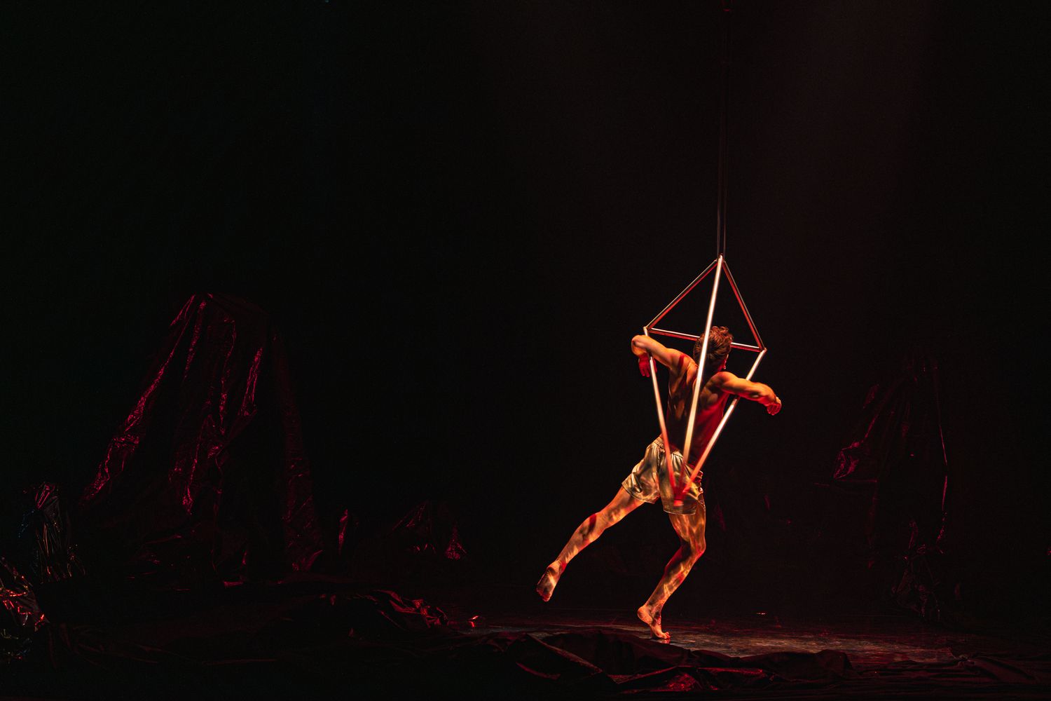 Red glowing neon lights create abstract shapes and patterns against a dark background, forming a dynamic visual display.