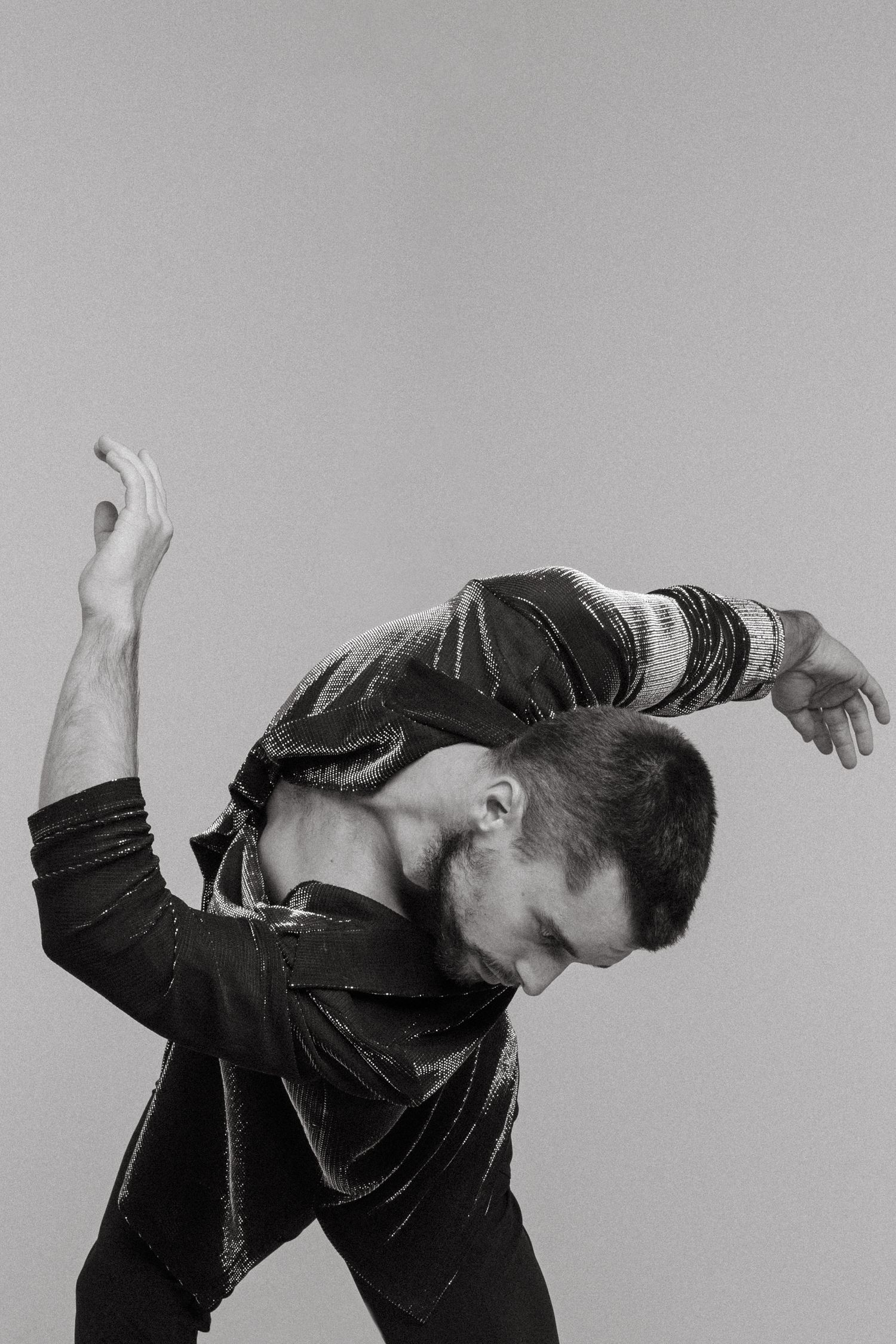 A dramatic monochrome photo series shows a figure in black bending backwards in an expressive dance sequence.