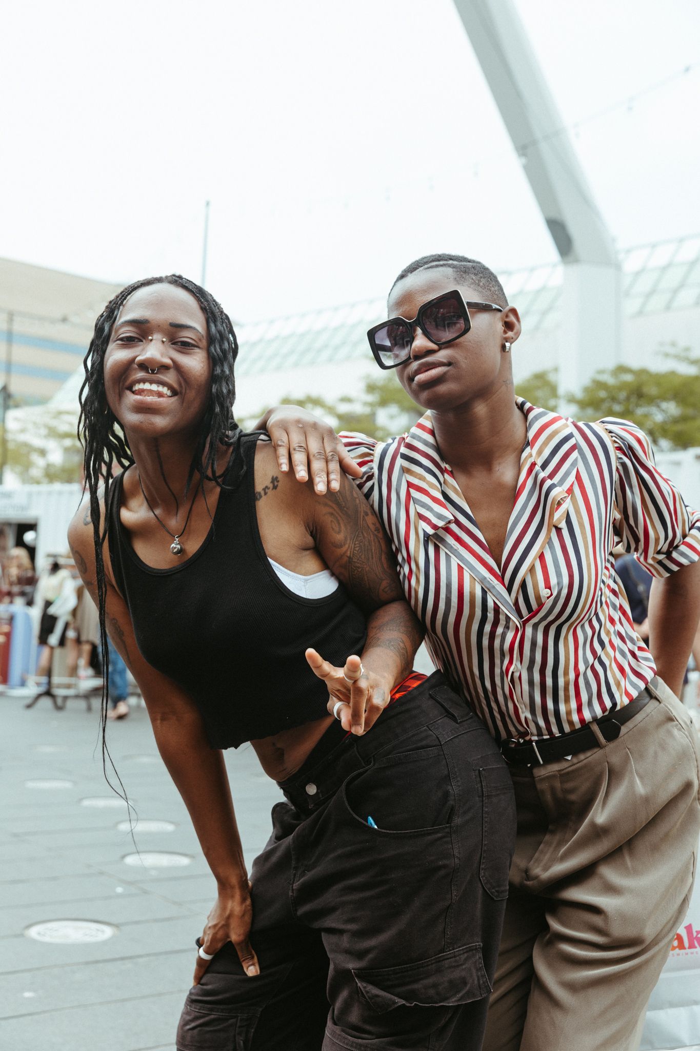 Friends in striped shirts and black outfits pose playfully together in a series of fun candid shots.