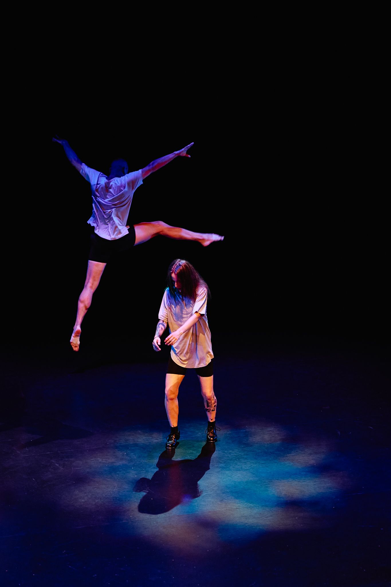 Dramatic sequence of a contemporary dancer performing fluid movements under blue and purple stage lighting.
