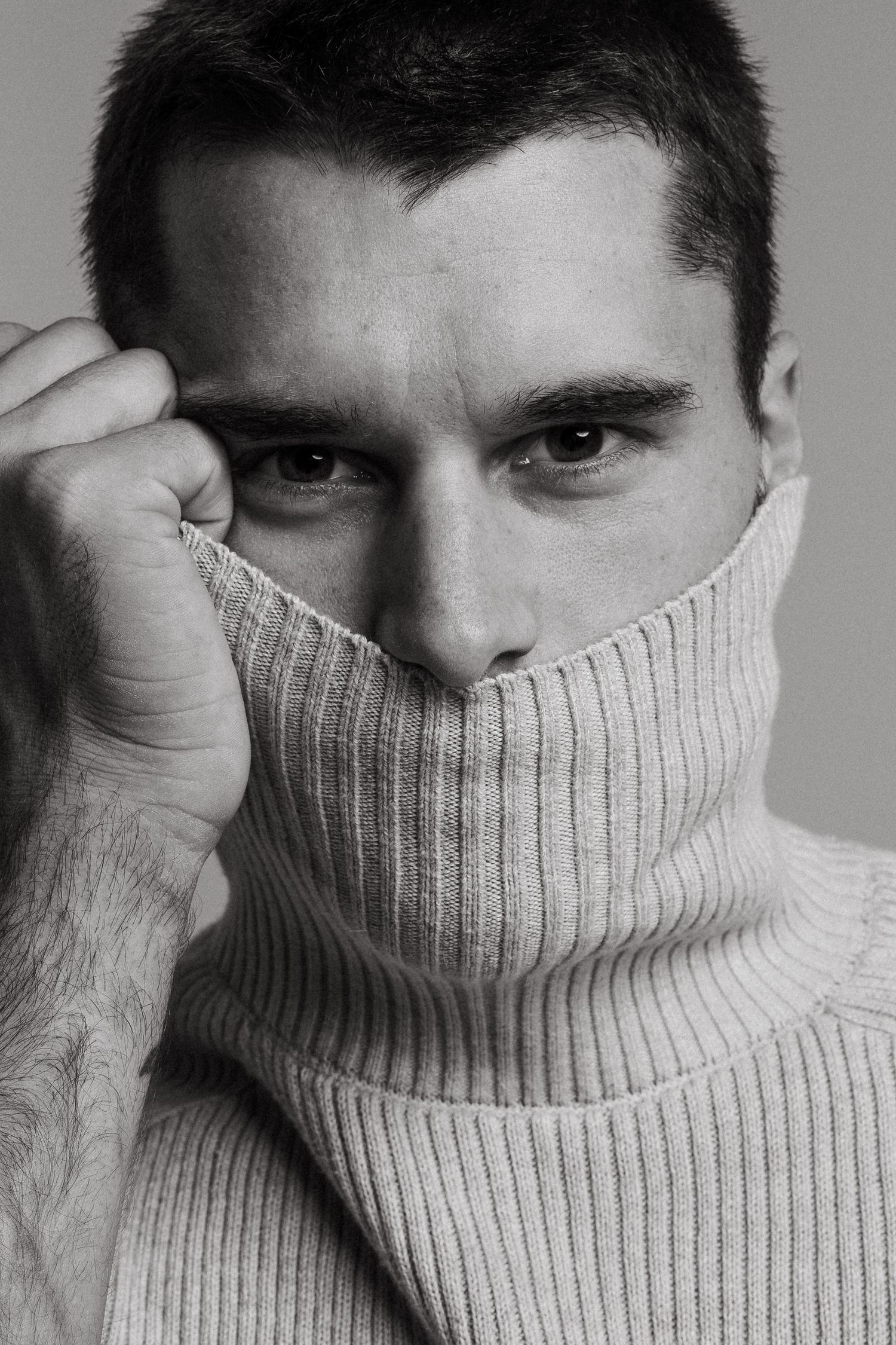 Series of artistic black and white portraits showing someone wearing a cozy white turtleneck sweater.