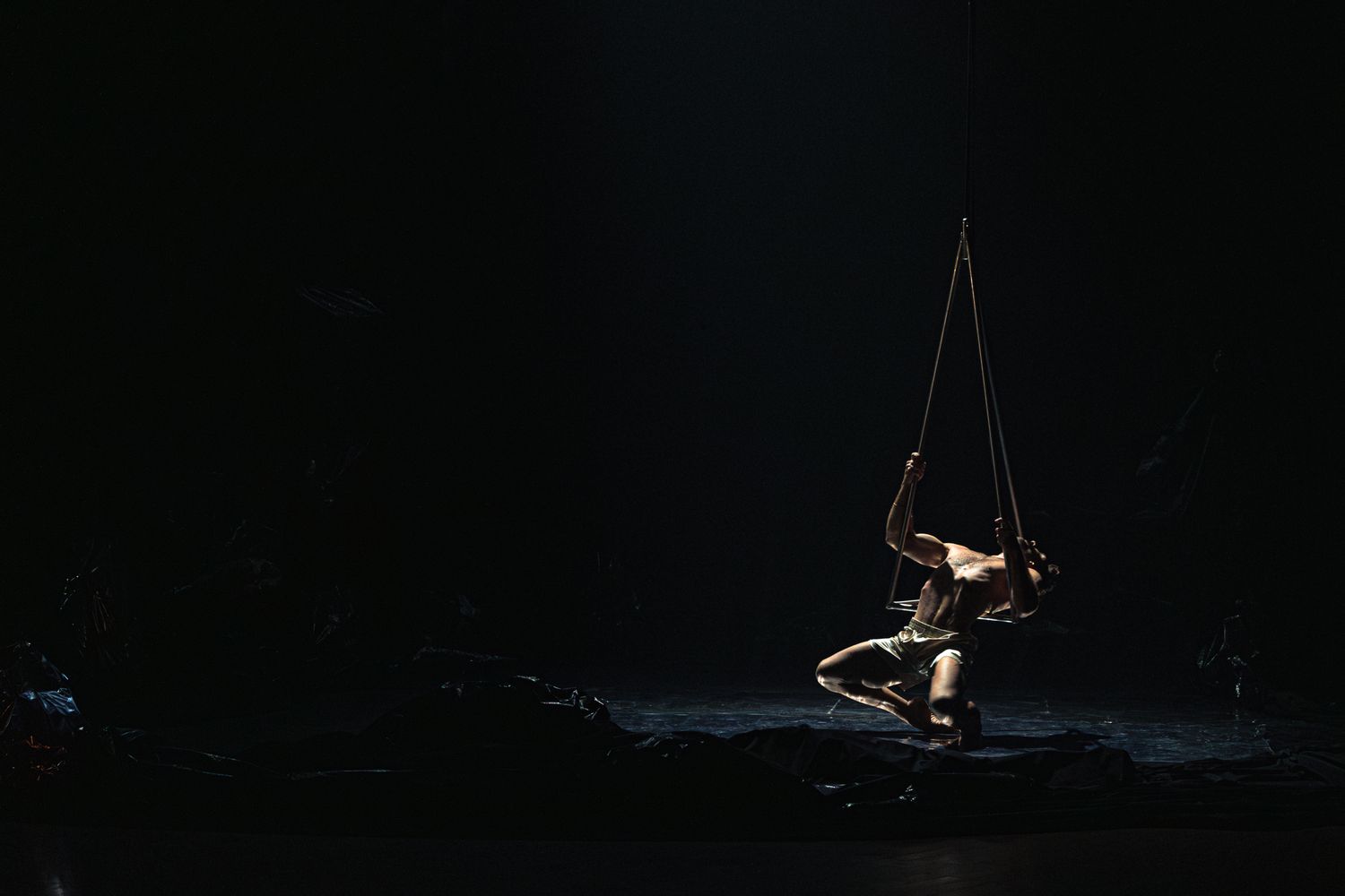 A set of dark silhouettes in low light conditions, showing figures in synchronized swimming or diving positions.