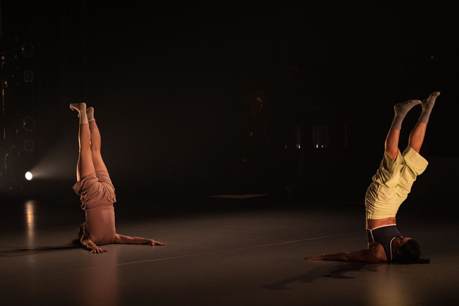Eight abstract dance performance photos showing figures in dramatic poses on a dark stage with dramatic lighting.