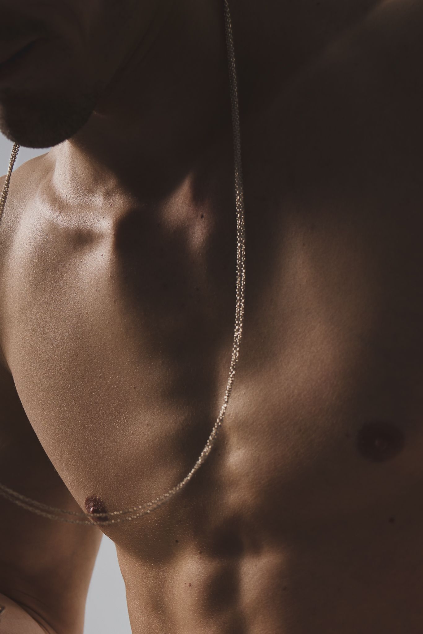 A close-up artistic sepia-toned photo series showing neck and shoulder silhouettes in dramatic lighting.