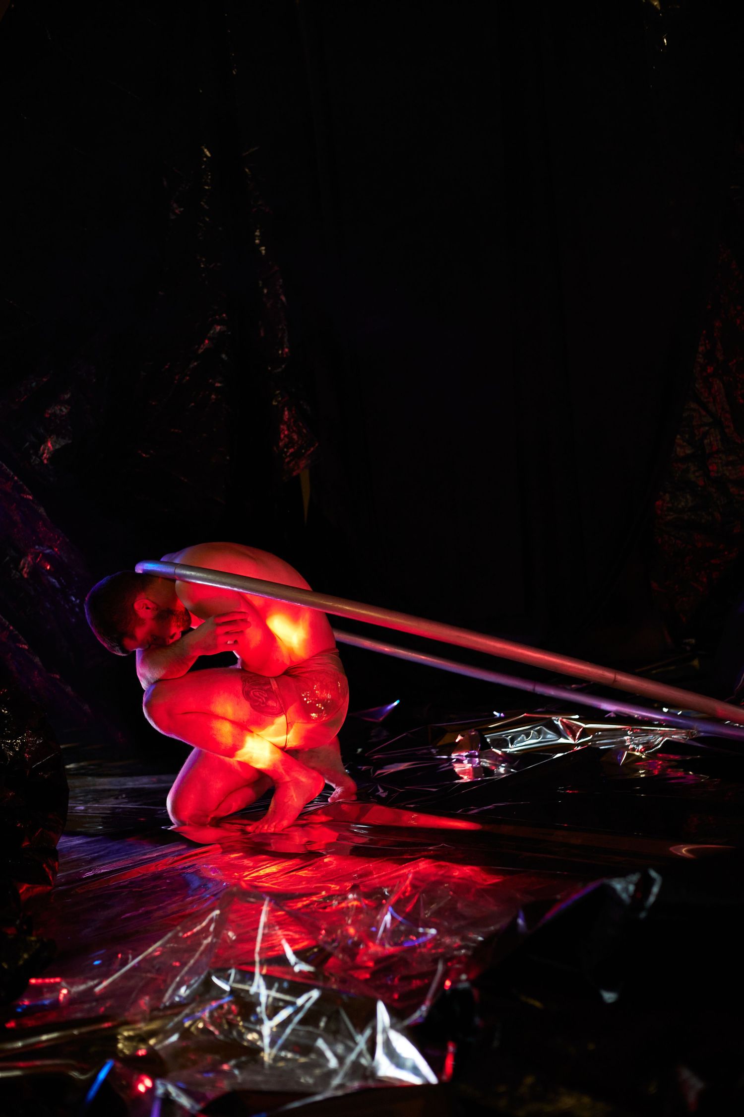 Experimental long exposure light painting photograph showing red illumination and streaks in a dark environment.