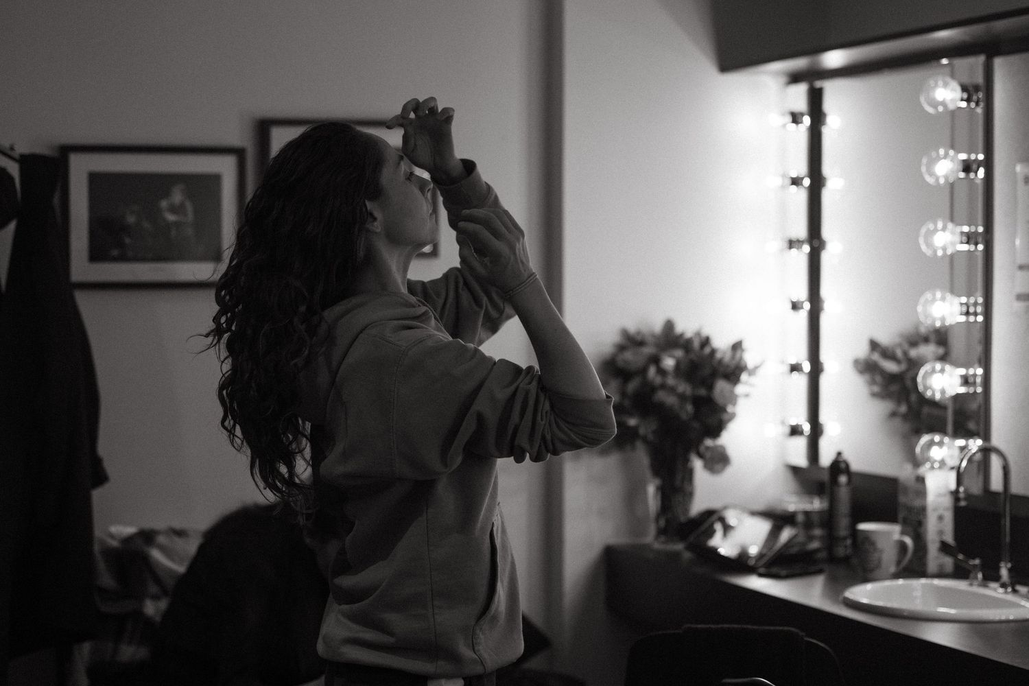 A black and white 4-panel sequence shows a person gazing at themselves in a mirror, reflecting somber expressions.