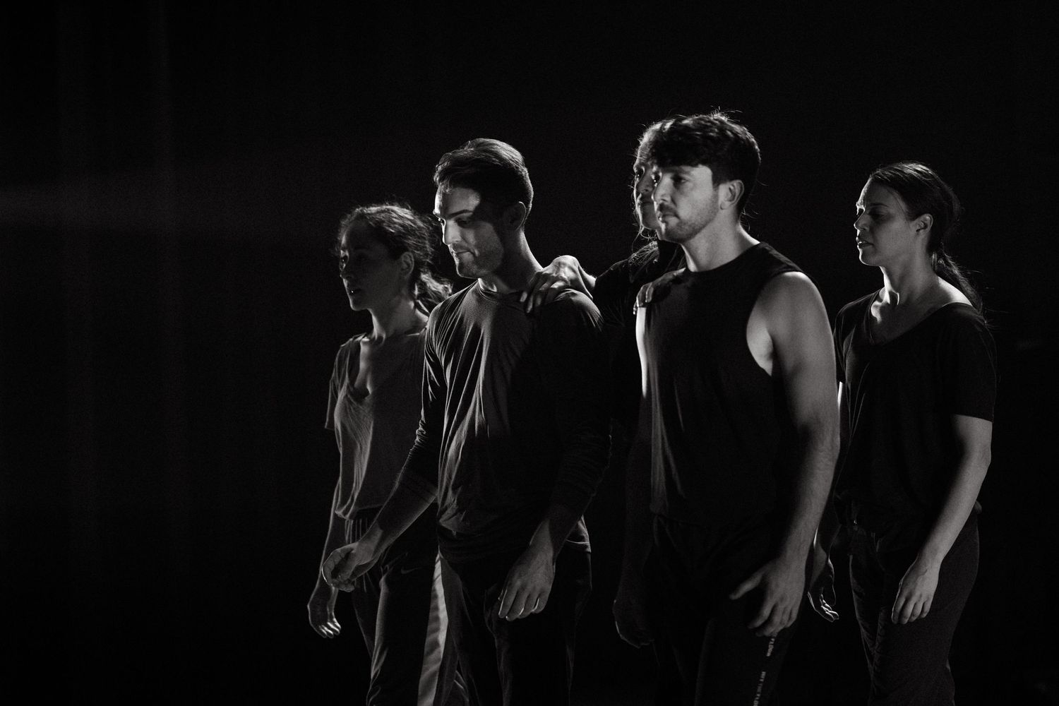 Black and white performance art sequence showing flowing movement and dance gestures in low light conditions.
