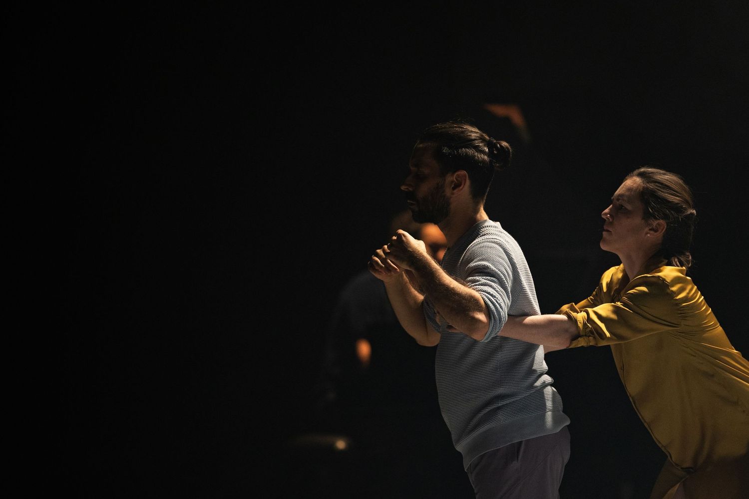 A sequence of intimate dance movements captured in six moody, low-lit frames shows dancers performing a romantic dance.