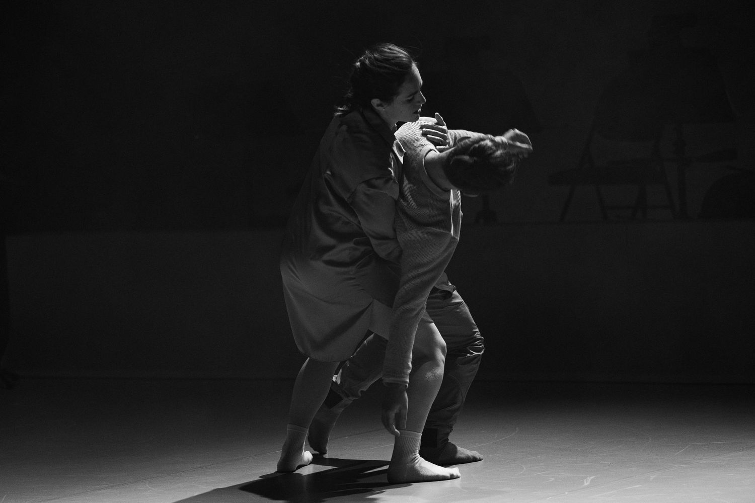 A dramatic black and white photo series shows a solo performer dancing with dynamic movements in dark lighting.