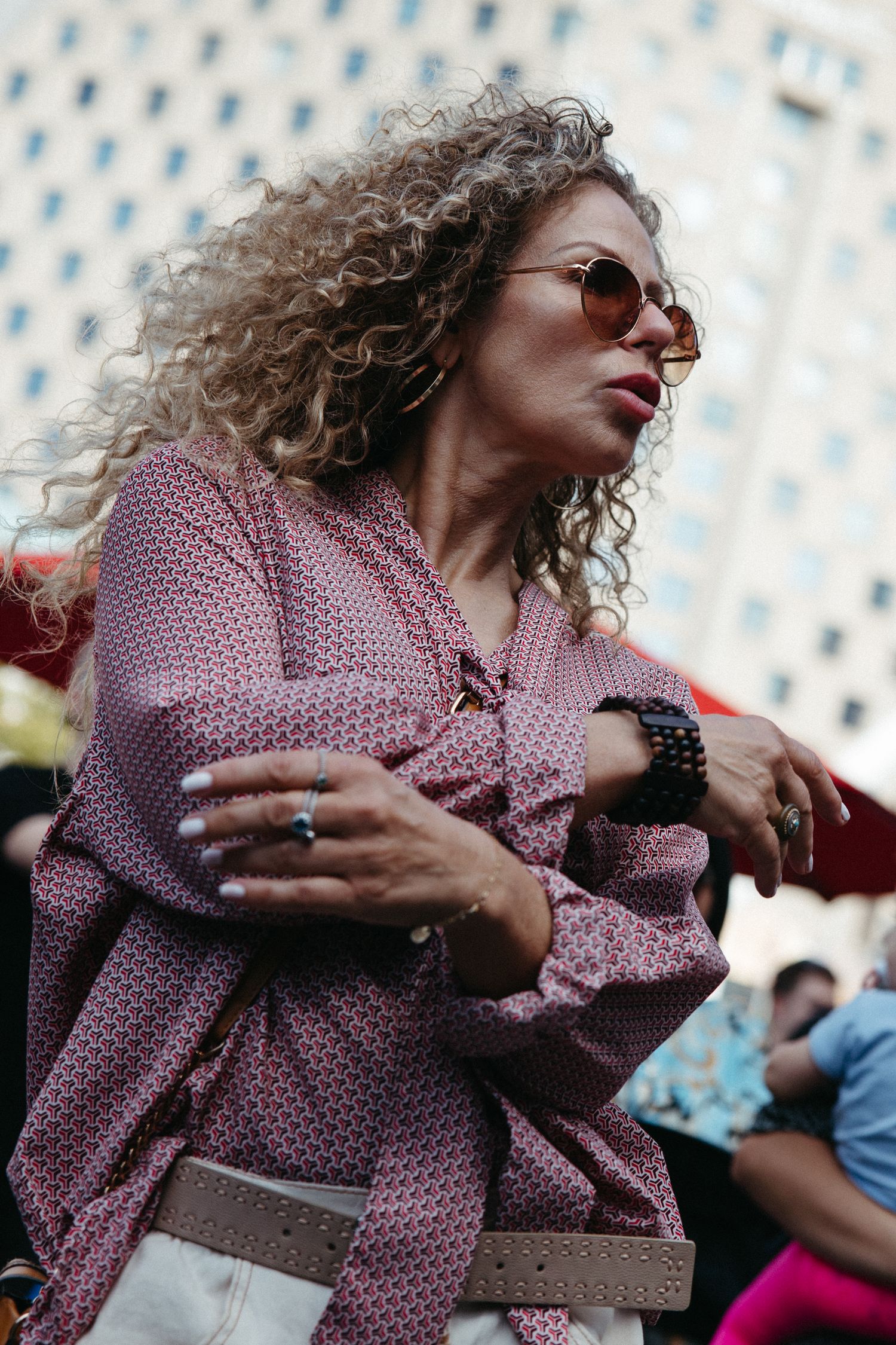 A person in sunglasses and polka dot shirt dances enthusiastically in a series of expressive movement photos.