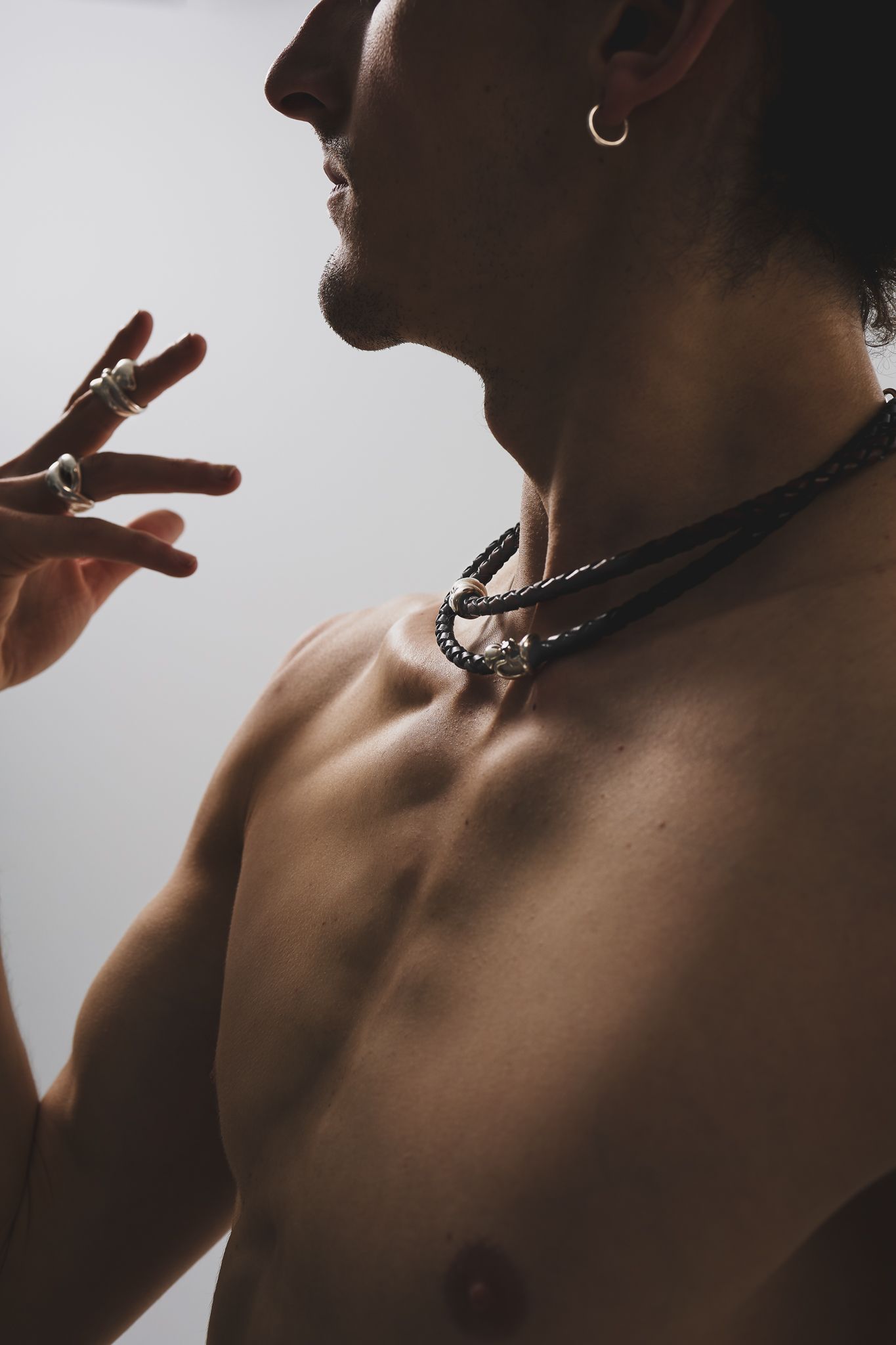 Artistic portrait series showing close-up fragments of a shirtless person's upper body in moody lighting.
