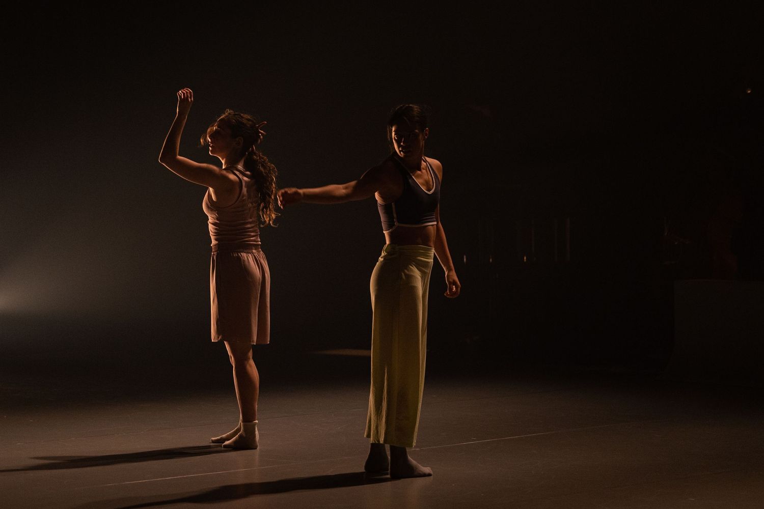 Dramatic series of dance performance silhouettes against dark background with warm spotlighting.