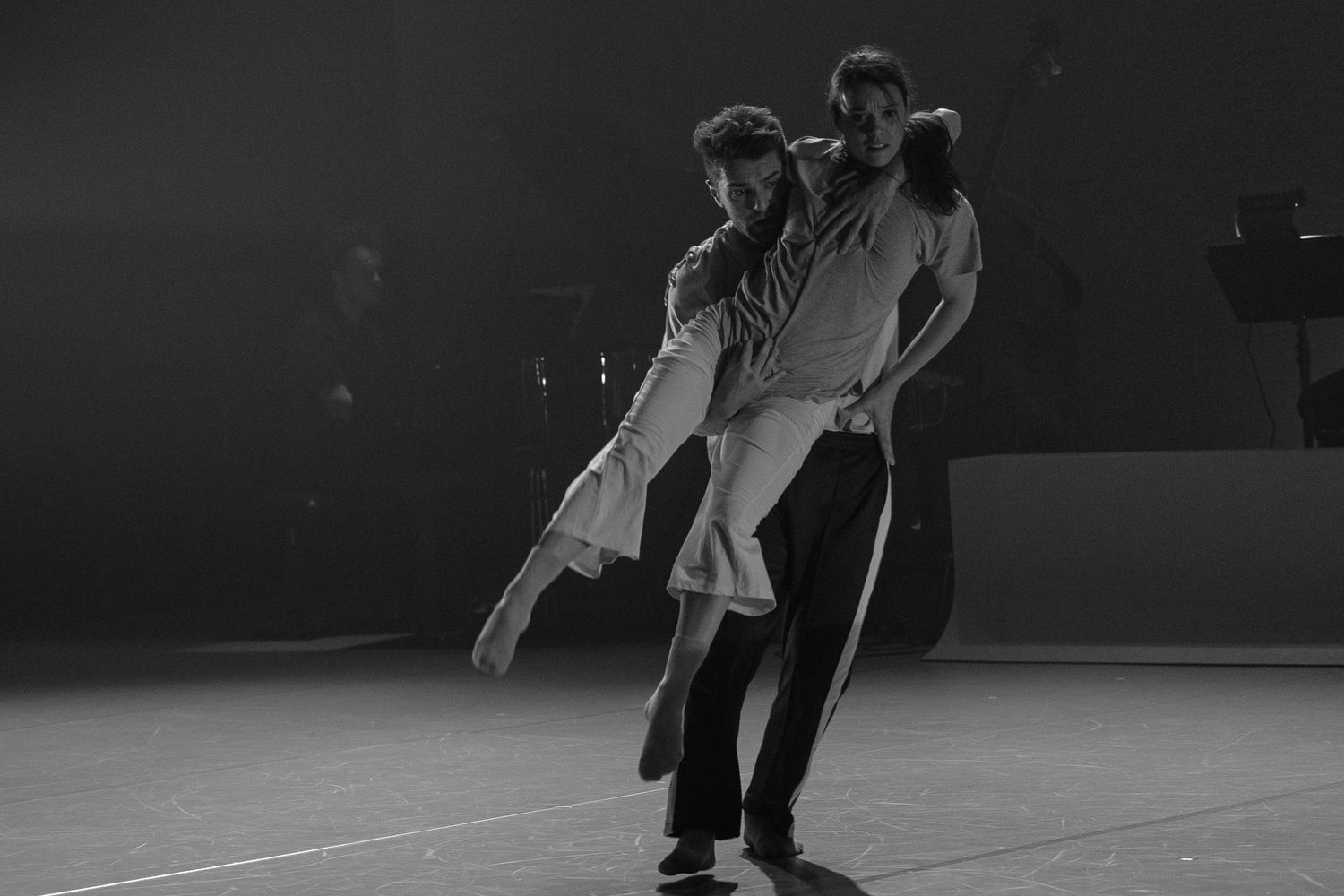 Black and white figure skating action sequence showing pairs skaters performing dramatic jumps and lifts on ice.