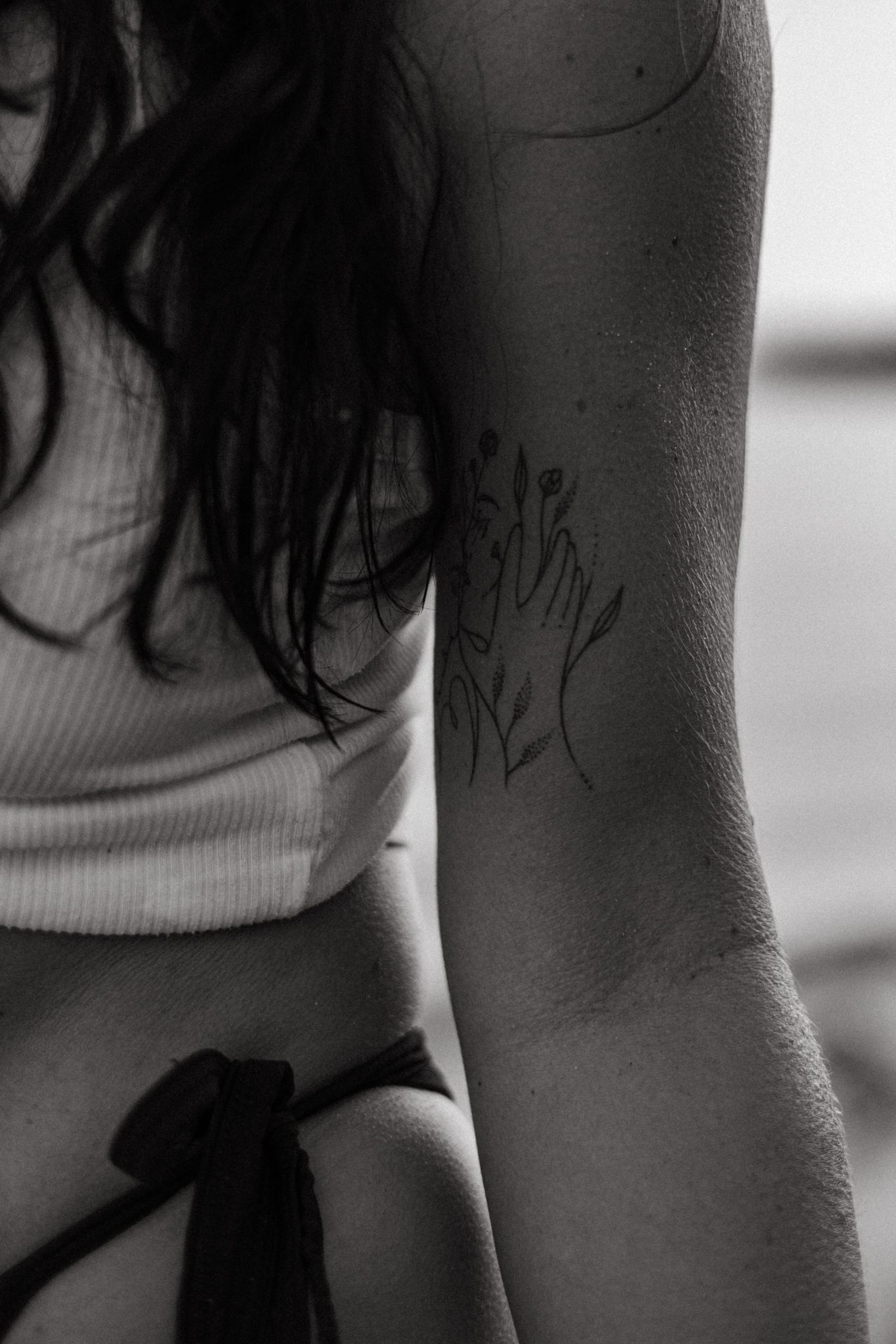 Black and white collection of close-up shots showing partial Roman numeral tattoos on skin.