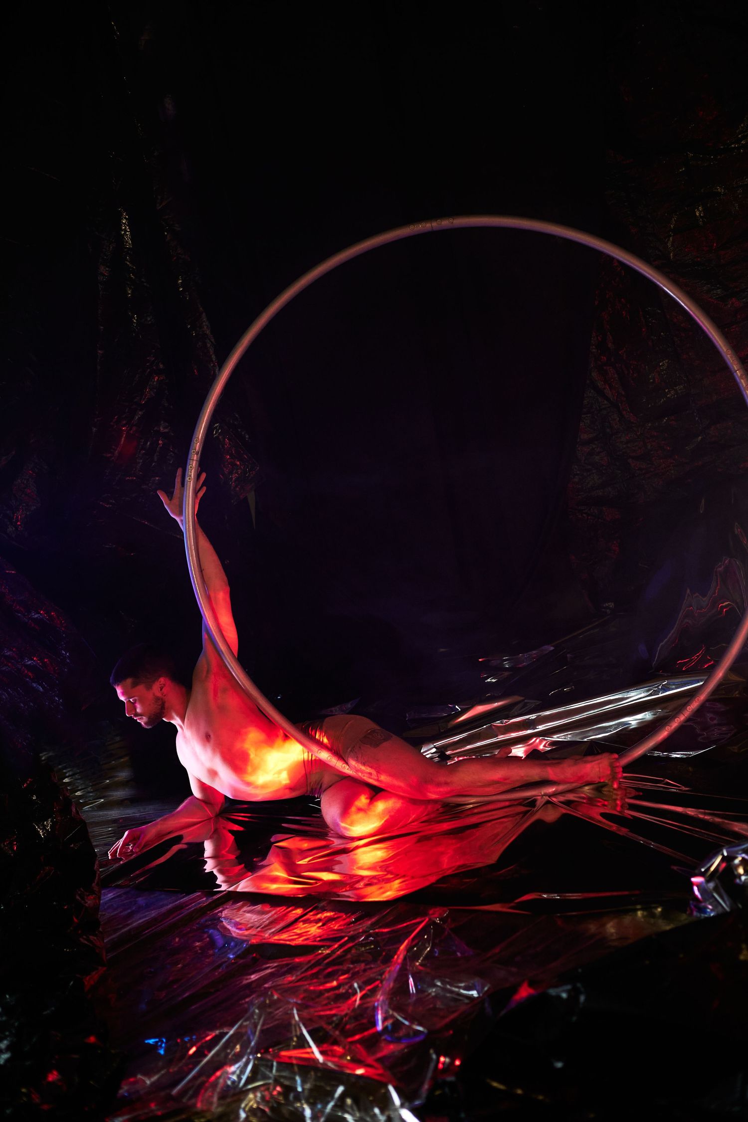Abstract 3D digital artwork in red and black showing dynamic flowing shapes against a dark background.