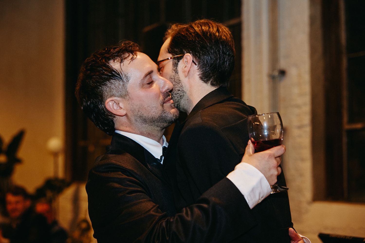 Multiple shots of two people in black formalwear embracing during what appears to be a special event.