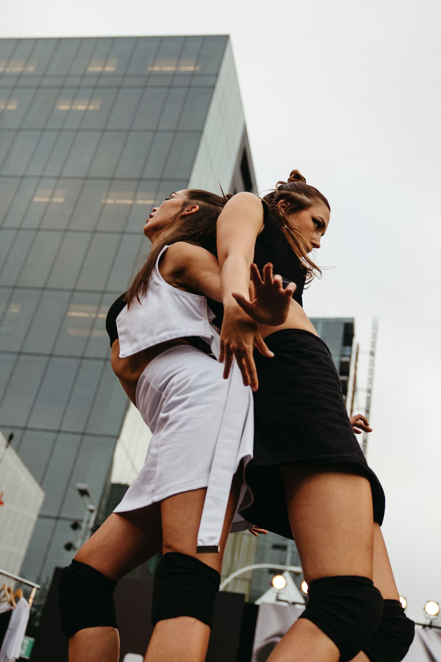 Three dance performance photos show dancers in black and white outfits performing dynamic movements against an urban backdrop.