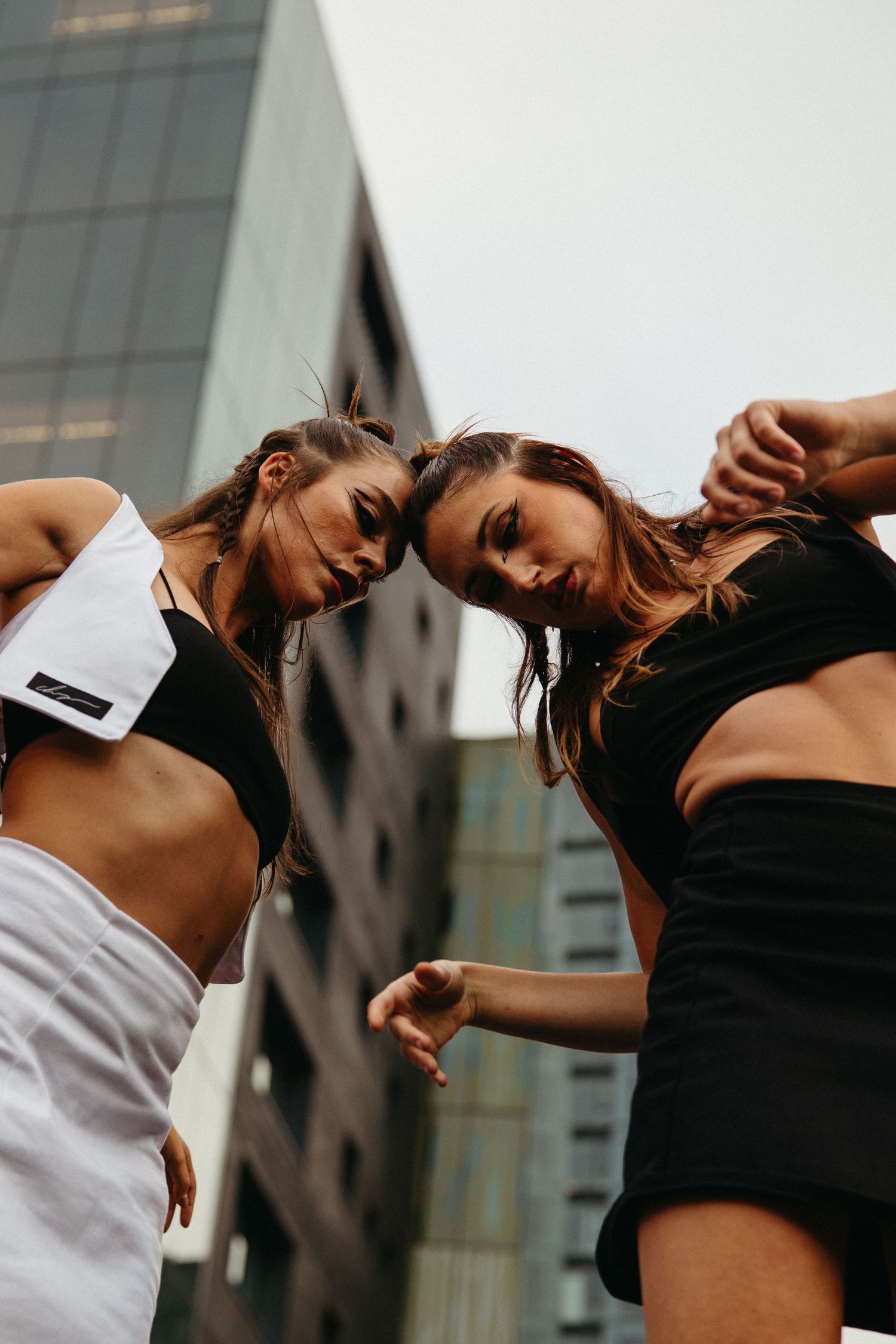 Artistic series of dance poses captured against urban architecture showing graceful movement and connection.