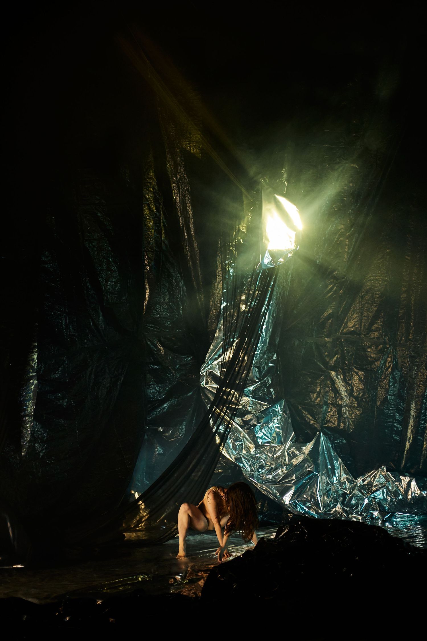 Mystical nighttime scene with glowing lights illuminating dark cave-like spaces and metallic reflective surfaces.