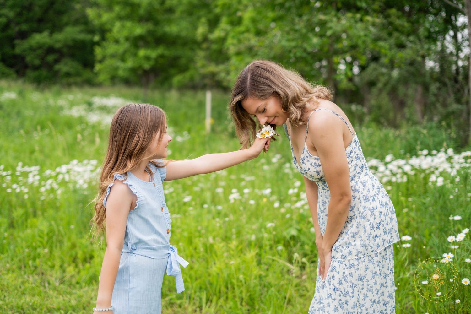 Playful summer portraits of people in a wildflower meadow wearing light floral dresses.