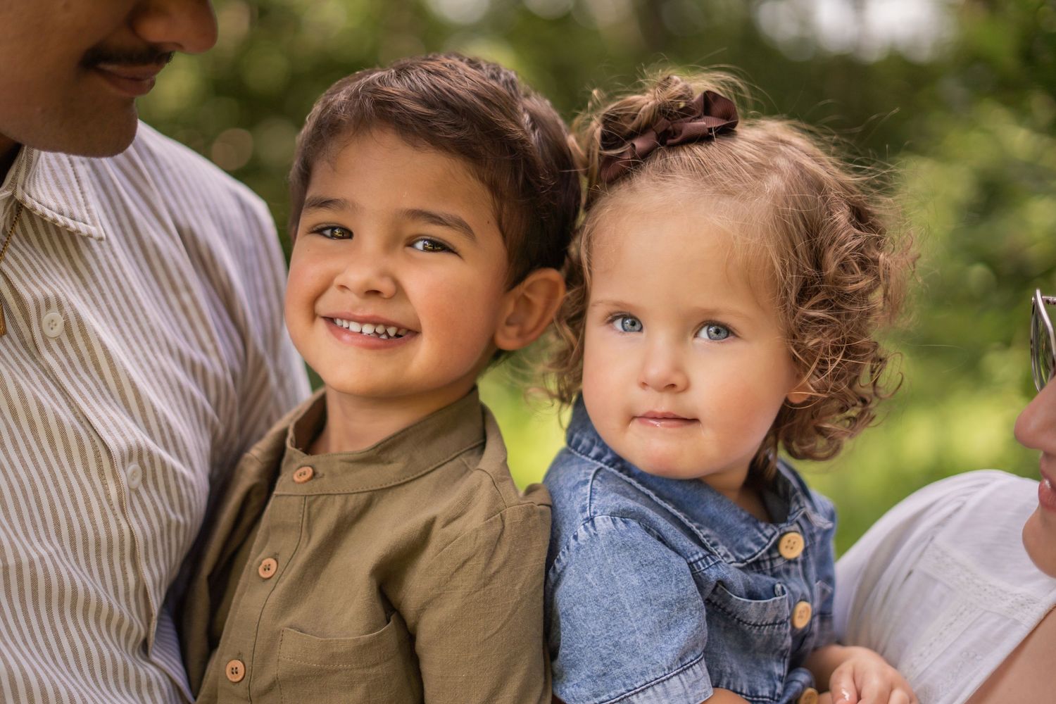 Candid family moments captured outdoors during a sunny day photoshoot.