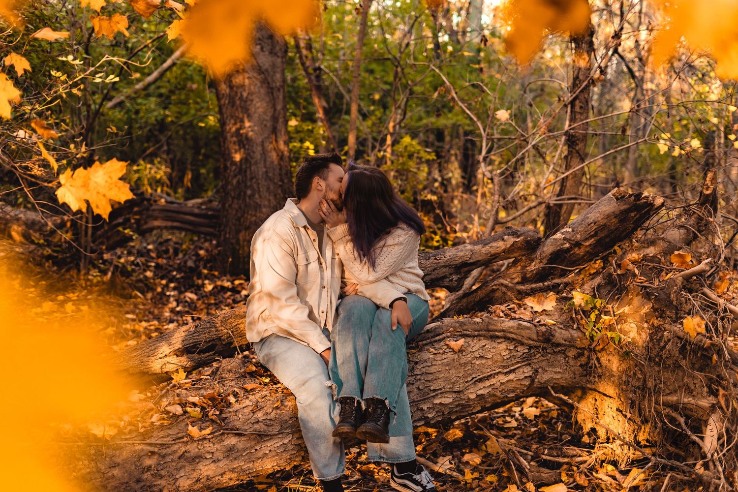 Fall family photoshoot with orange foliage creating natural bokeh effect.