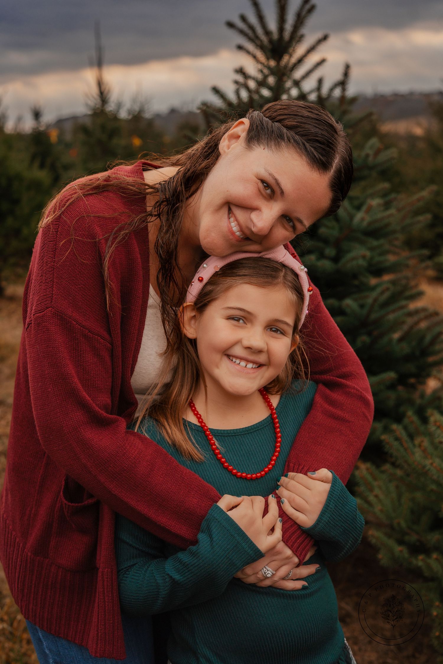 Sweet embrace captured at Christmas tree farm during sunset.