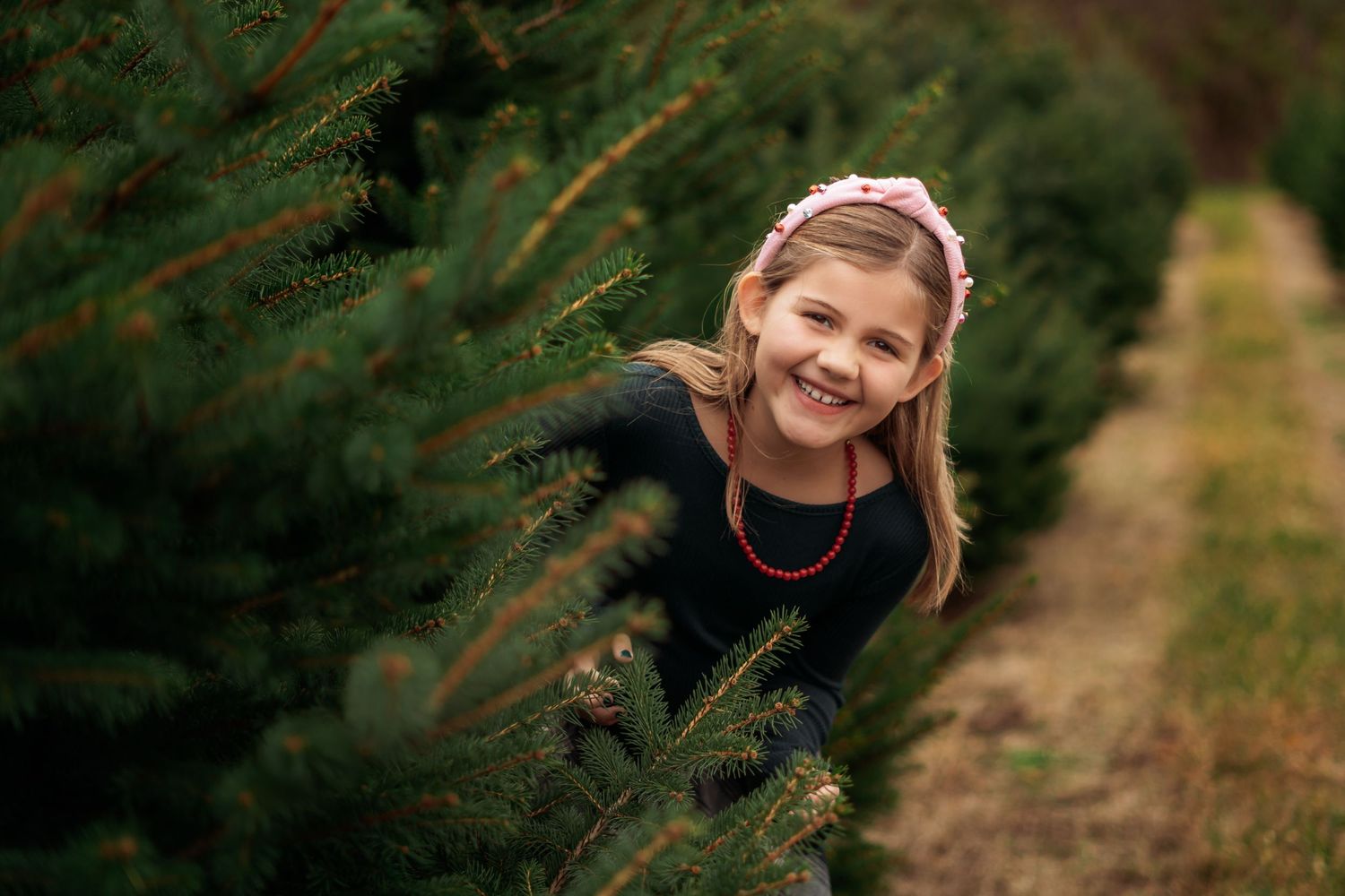 An outdoor portrait session among evergreen trees during autumn.