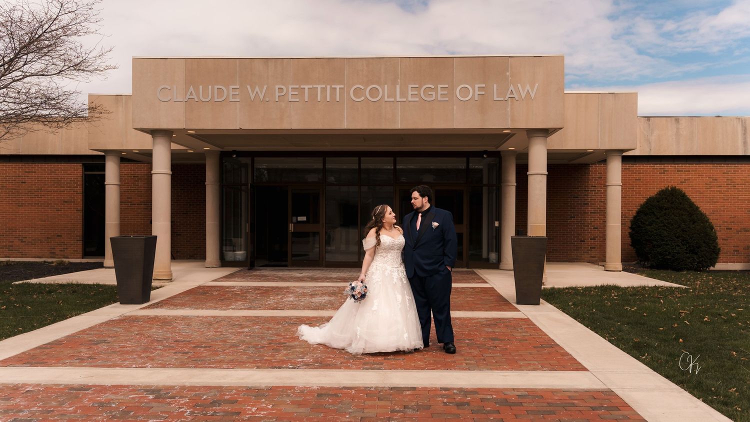 Panoramic view of a modern brick college building with 'College of Law' signage on a sunny day.