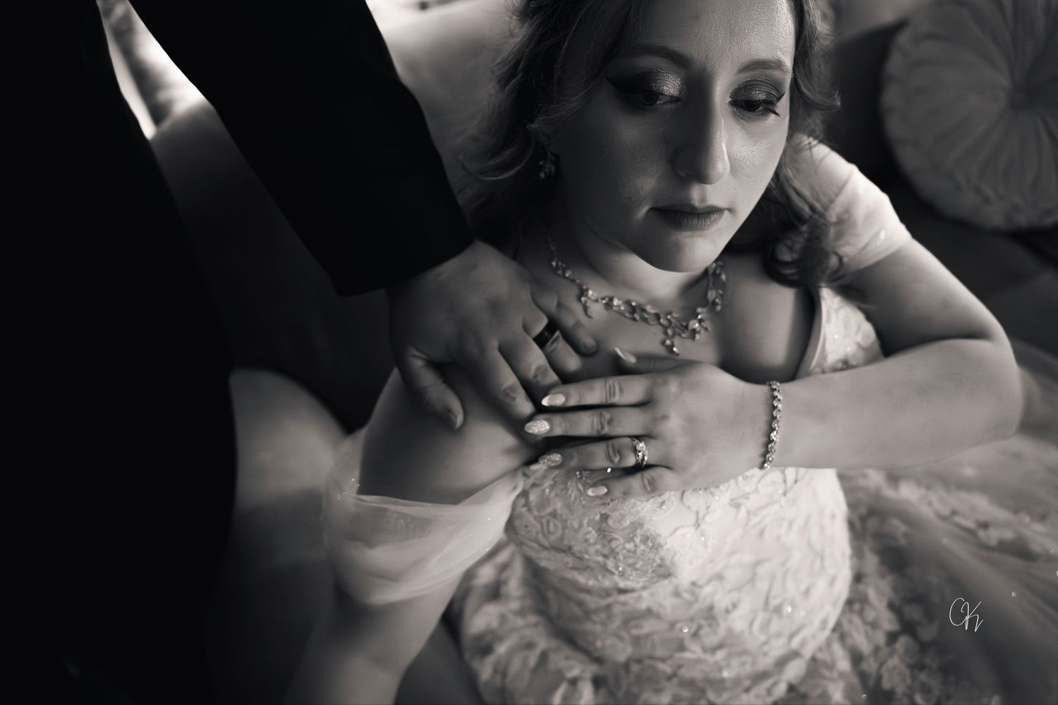 A black and white portrait captures an intimate moment of someone in an elegant lace dress.