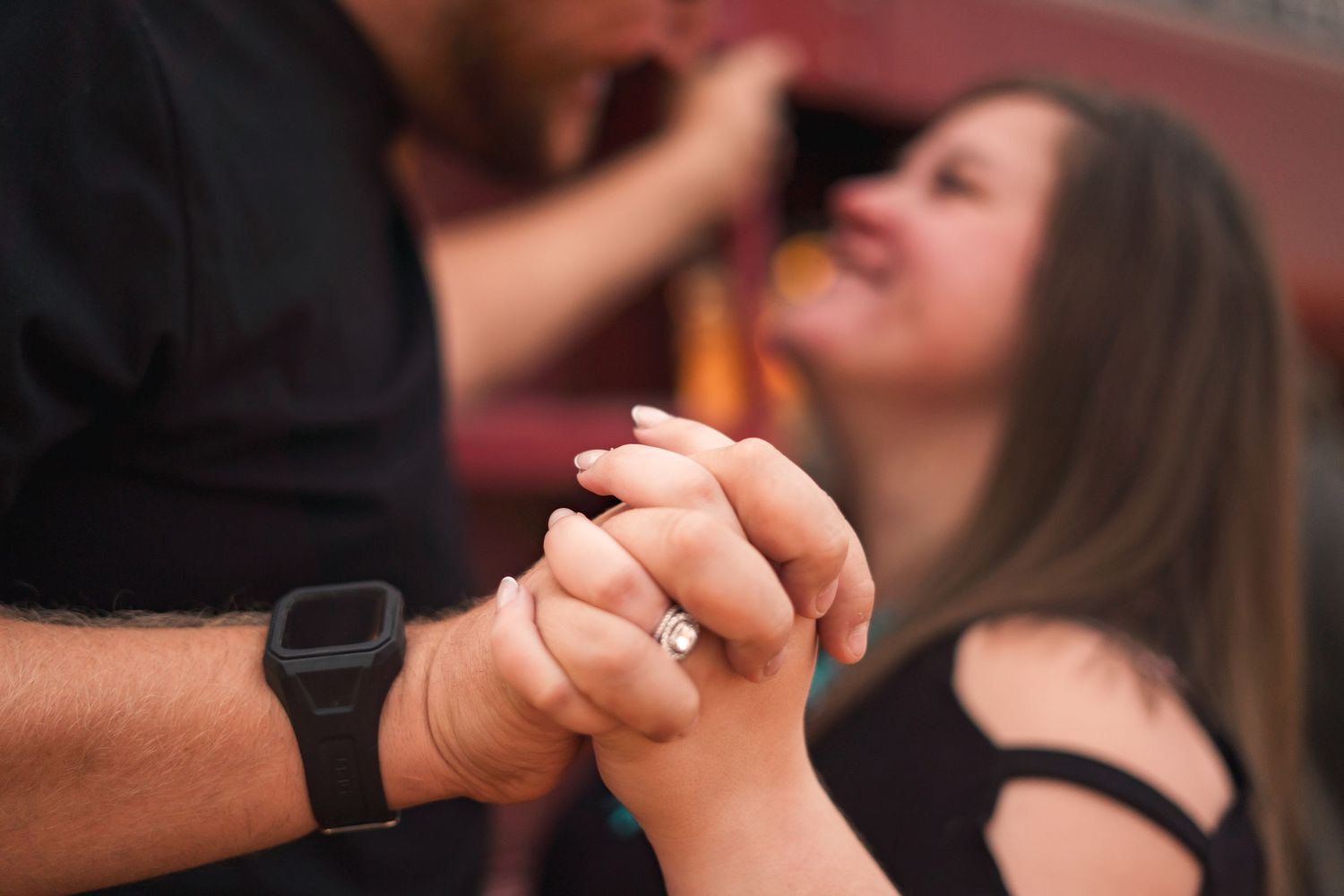 Close-up of couple holding hands during romantic moment.