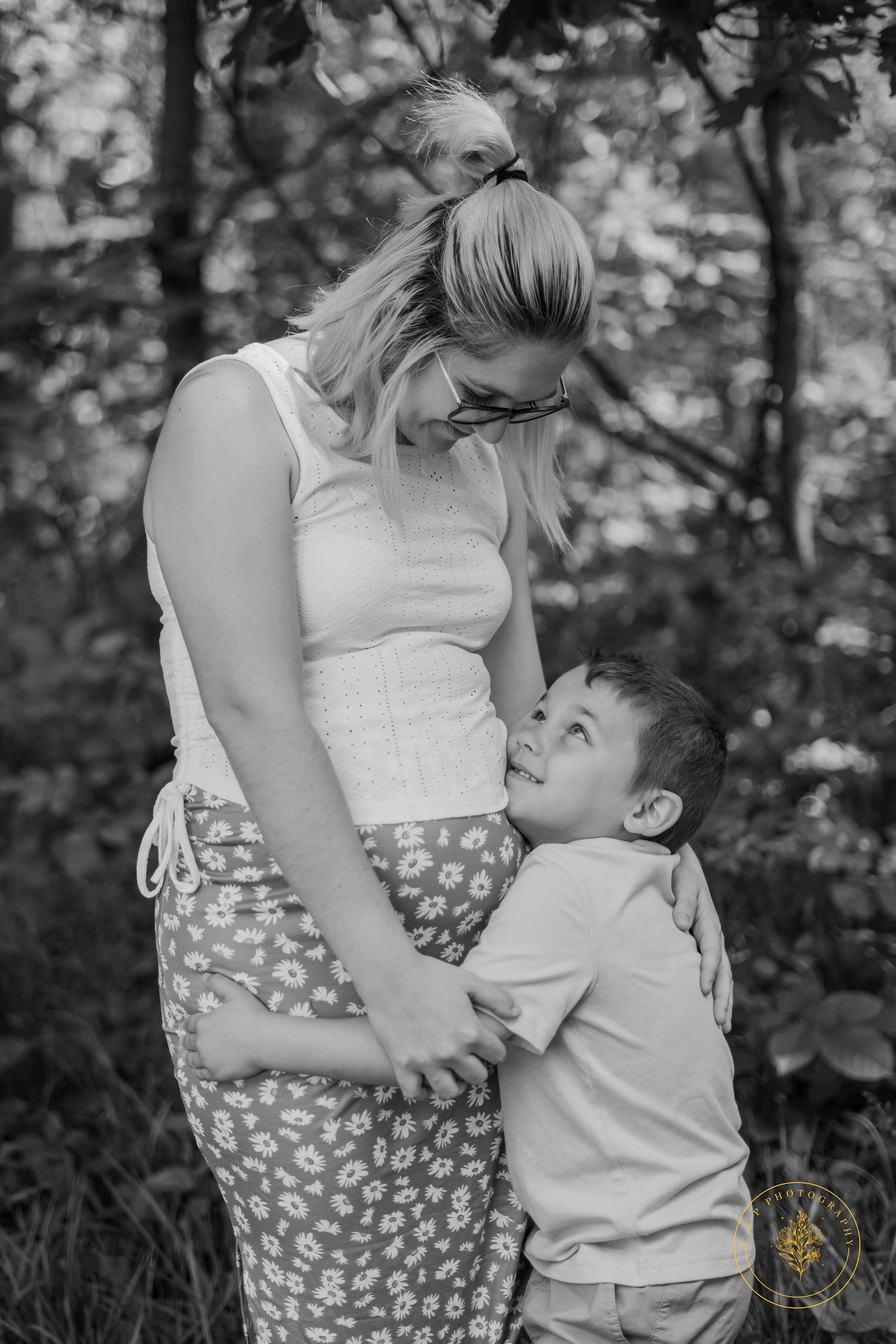 A black and white maternity photo series showing tender family moments.