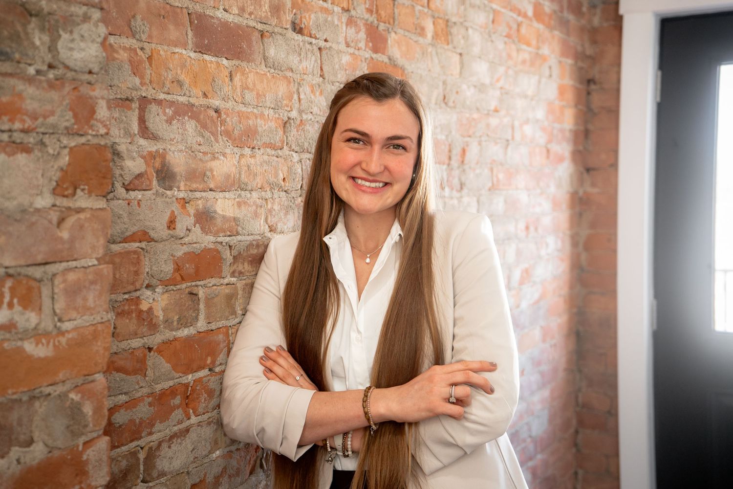 A portrait session against a rustic exposed brick wall background.
