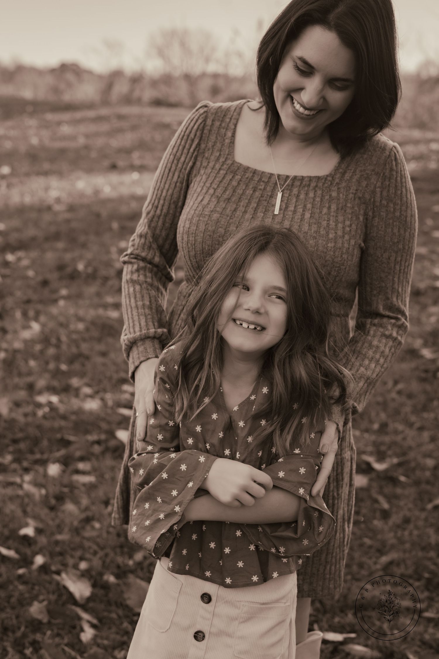 Candid sepia-toned portrait showing tender moment between two people.