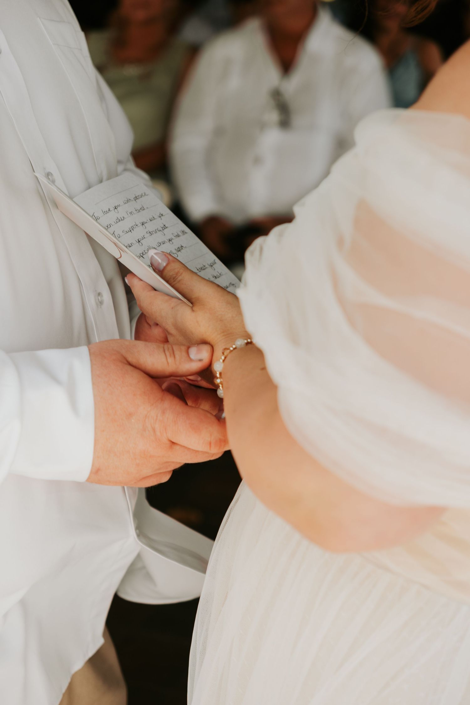 Hands exchanging wedding rings and vows during an intimate wedding ceremony closeup.
