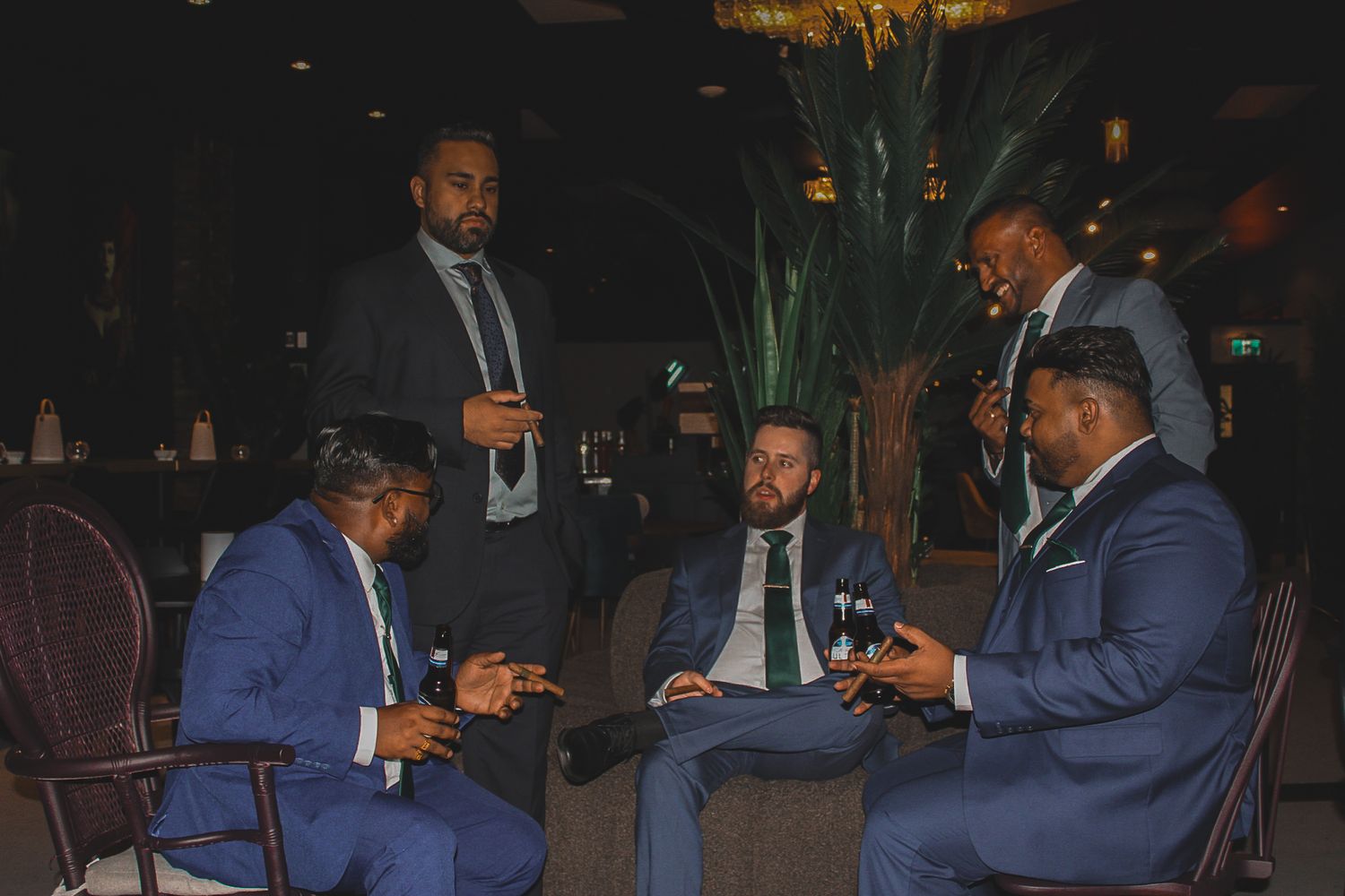 Men in formal attire gathered around a table during an evening celebration.