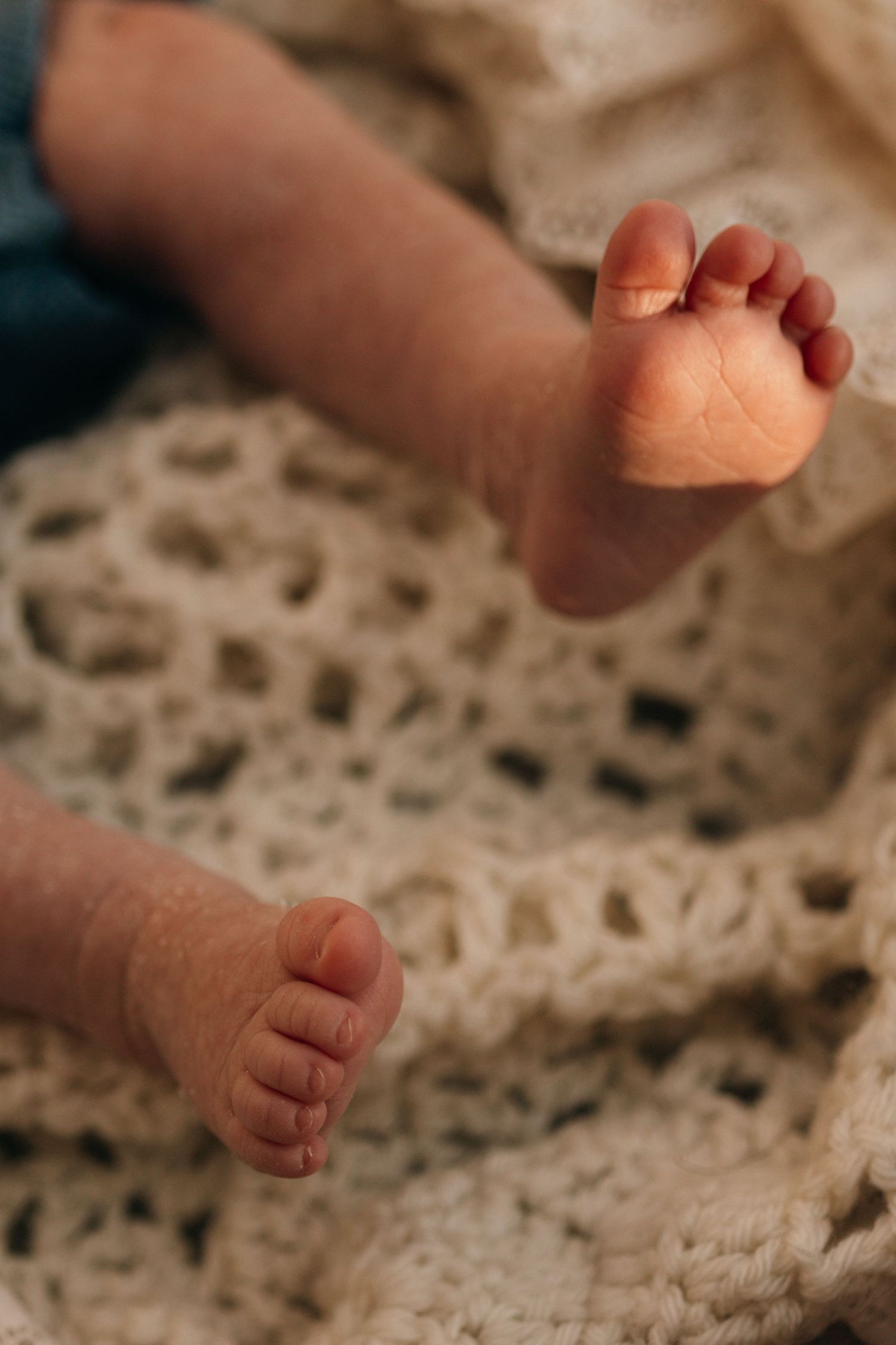 Close-up photos of tiny baby feet resting on textured knit fabric in warm natural lighting.