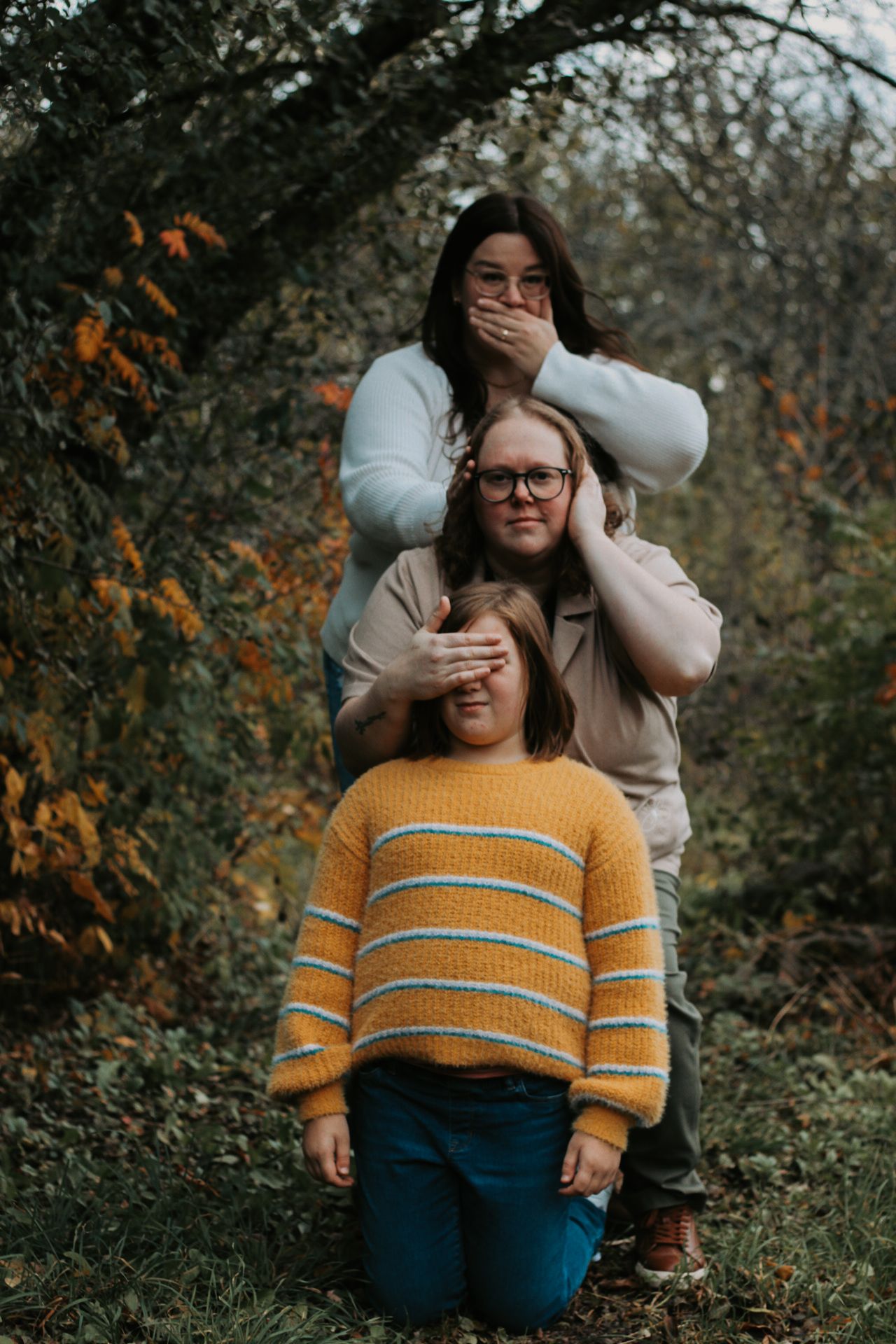 Playful family photo with see-no-evil hear-no-evil speak-no-evil poses.