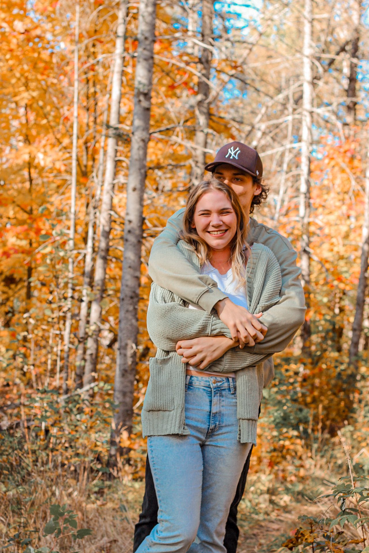 Autumn portrait in forest with golden leaves and warm sweater.
