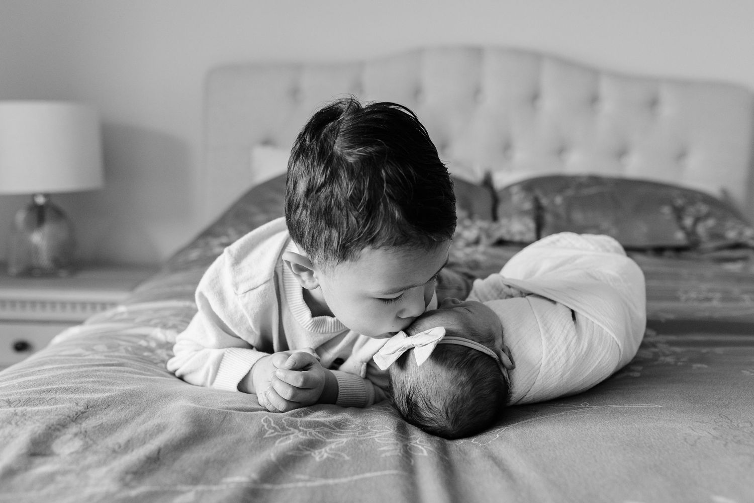 A serene black and white photograph on a tufted headboard bed.