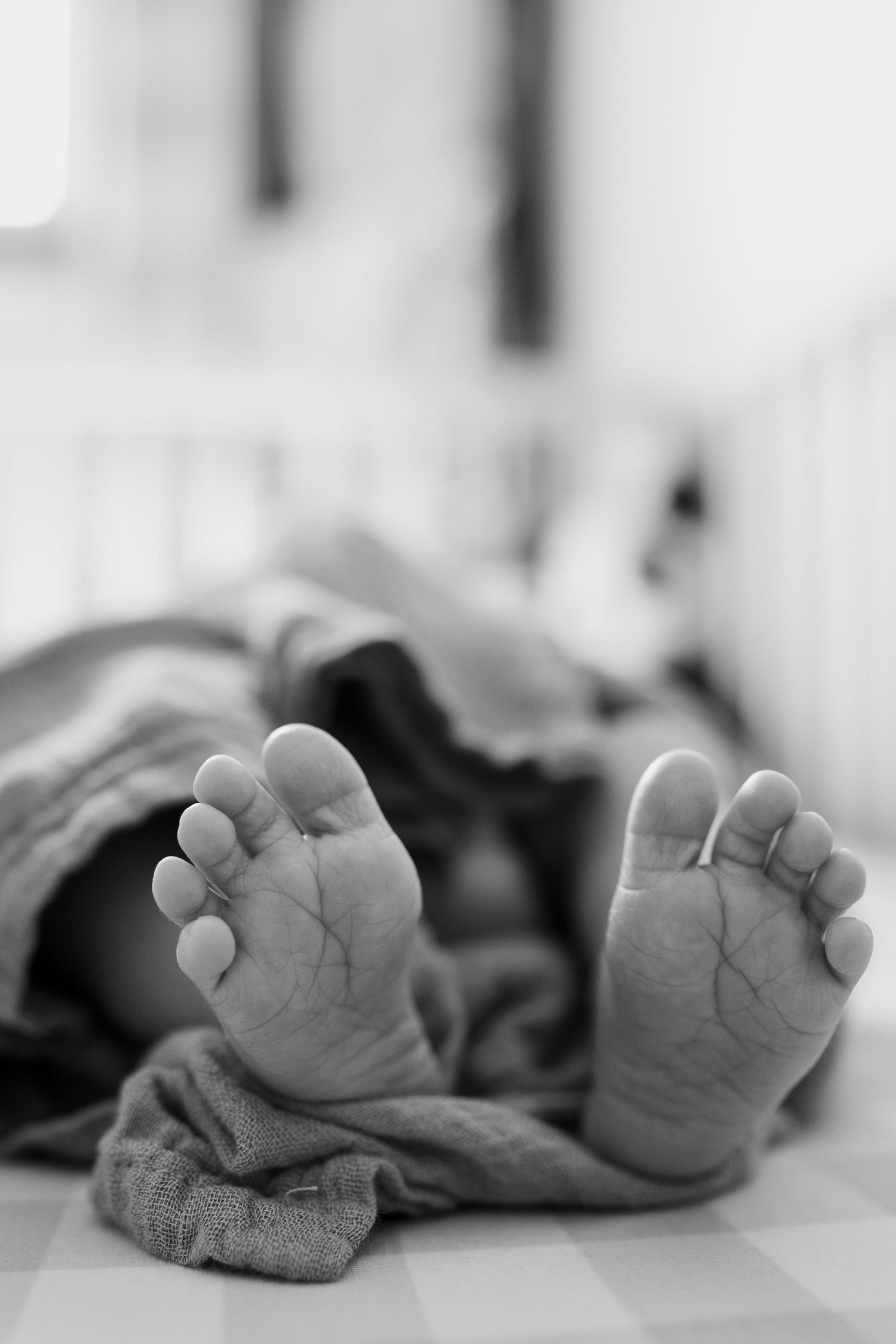 Close-up black and white photo of tiny newborn baby feet.
