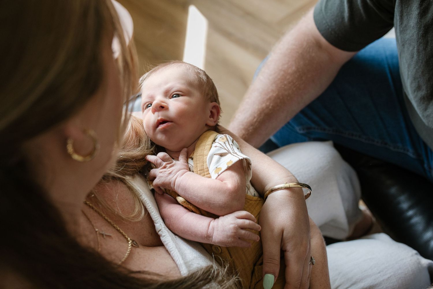 Natural light photographs capturing tender moments between parent and baby during feeding time.