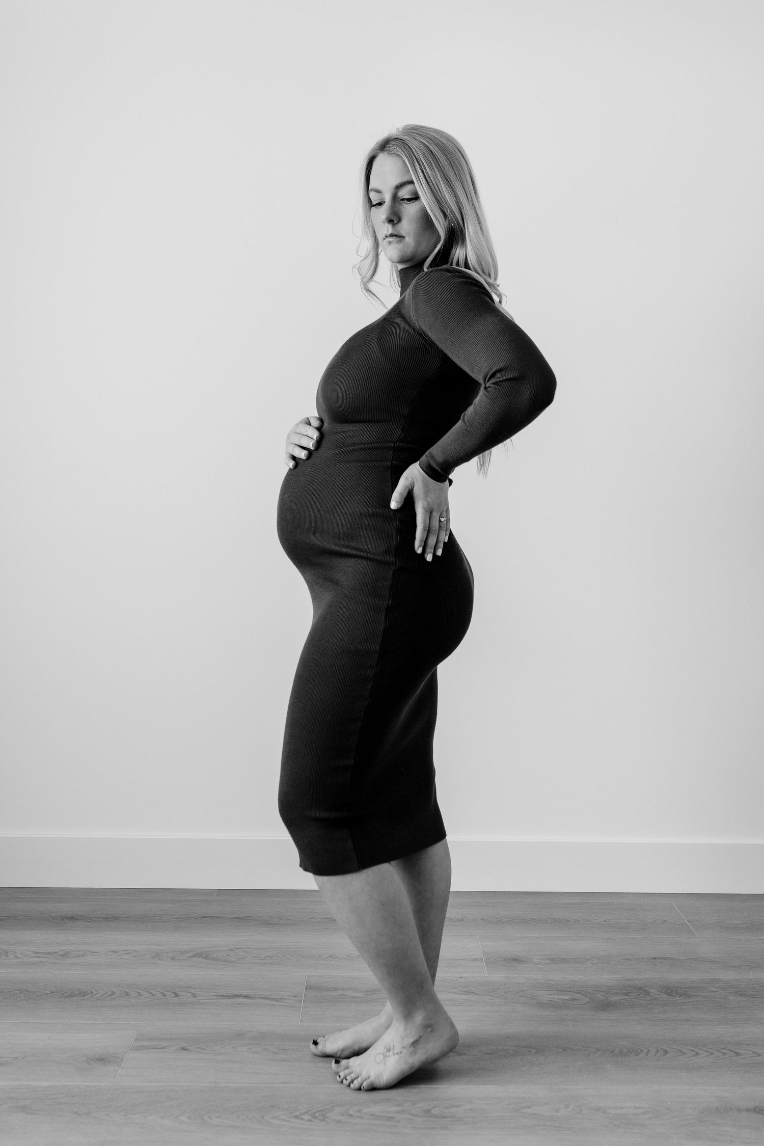 Black and white maternity portraits showing artistic standing poses.