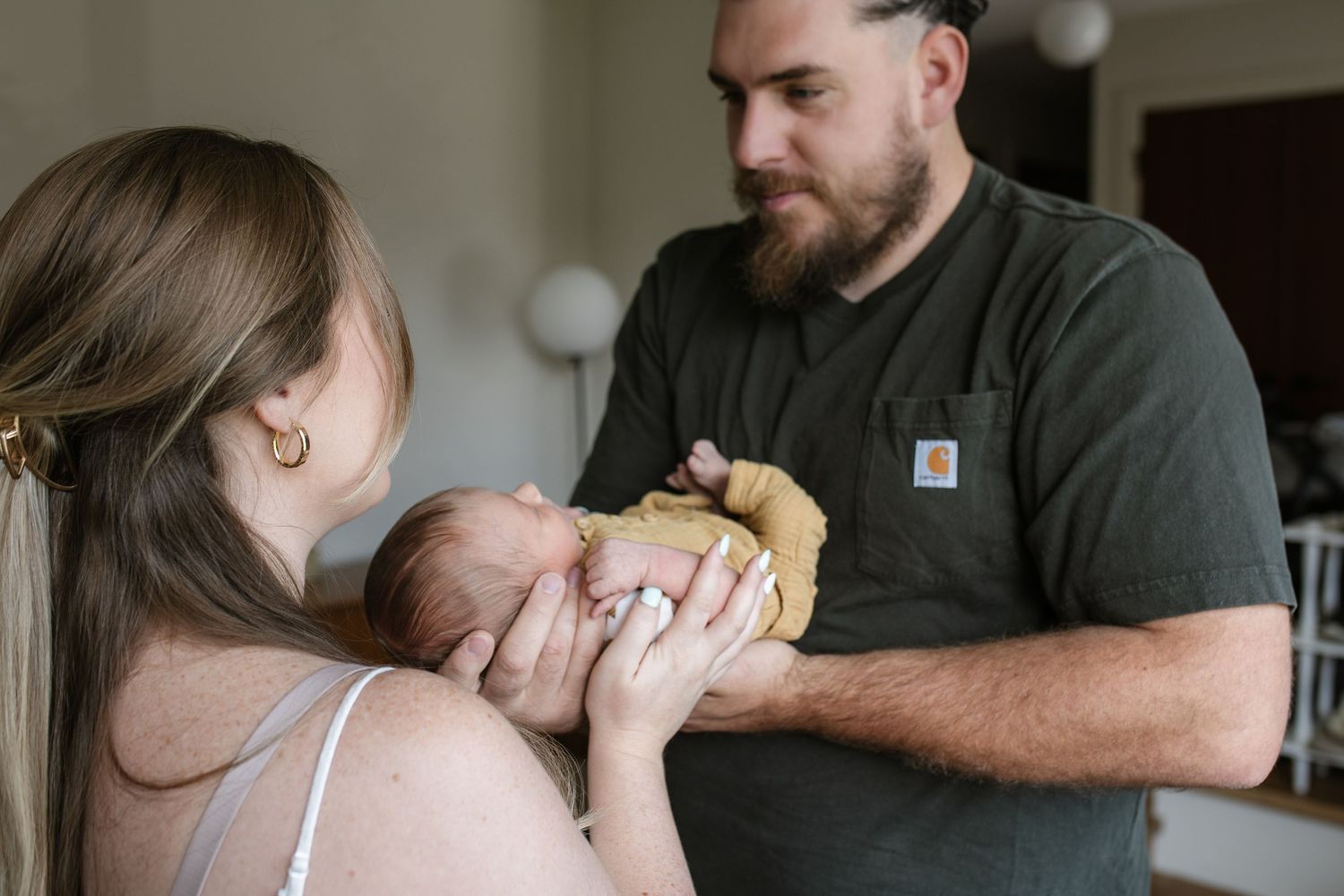 Documentary style images showing quiet moments between parent and newborn at home.